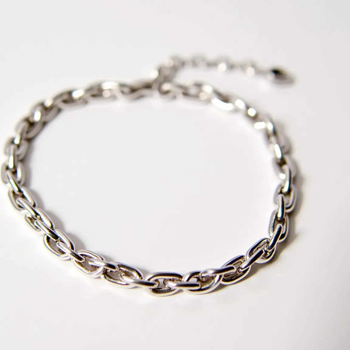 This ankle bracelet features a sleek, linked chain design composed of a polished, likely metallic material, which gives it a refined yet simple appearance. Each link in the chain is uniformly shaped, demonstrating meticulous craftsmanship. The bracelet is secured with a classic clasp mechanism, providing ease of wear and removal. There are no visible gems on this piece, making it a minimalist and versatile accessory suitable for various occasions.