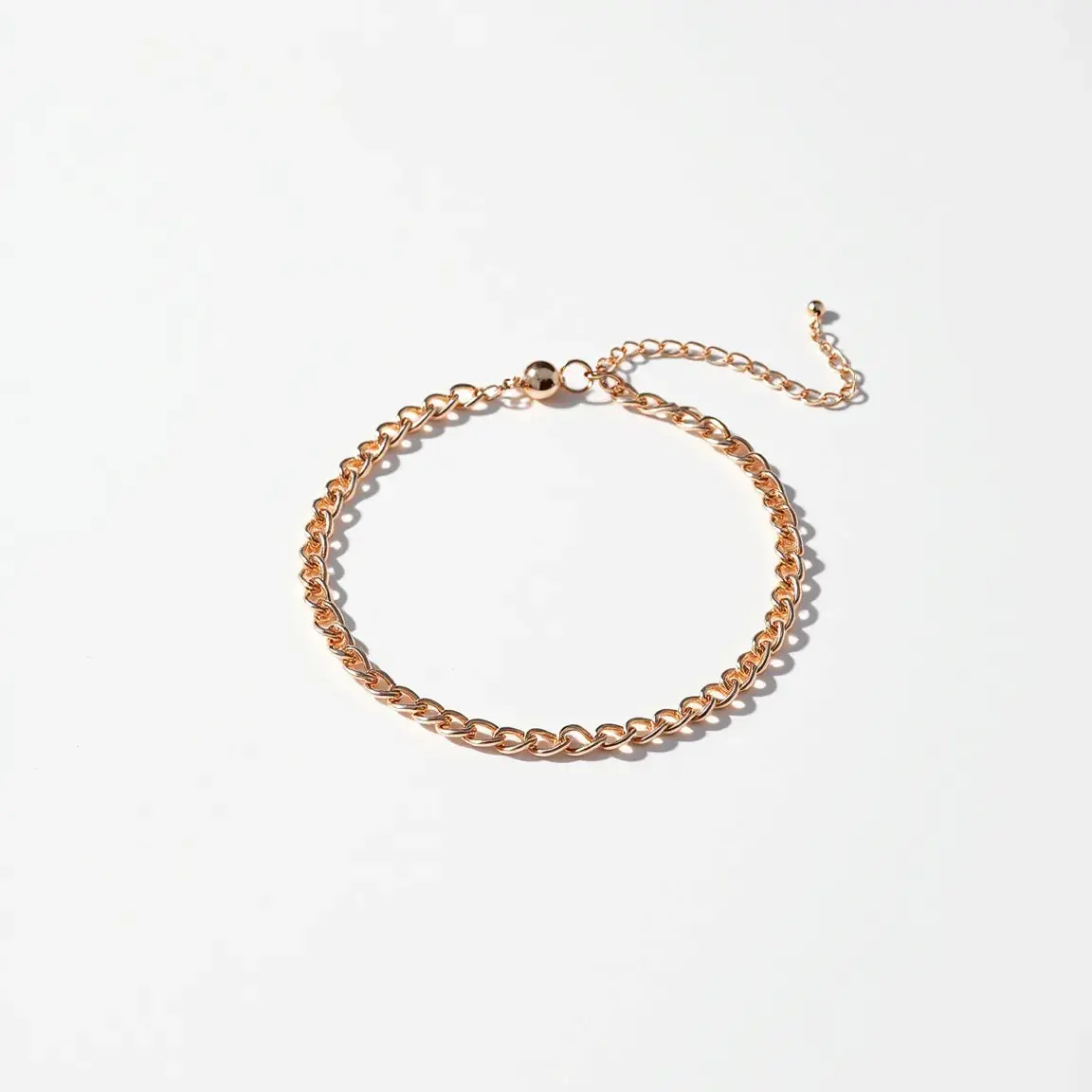 This ankle bracelet showcases a sleek design with a chain made of polished metal, likely gold or gold-toned material, giving it a luxurious appearance. The bracelet features a classic chain link pattern, which adds an element of elegance and sophistication. The piece includes an adjustable extension chain with a small bead at the end, allowing for a customizable fit. At the other end of the bracelet, there is a secure lobster clasp that ensures the bracelet stays in place when worn. Overall, its refined design makes it a versatile accessory suitable for various occasions.