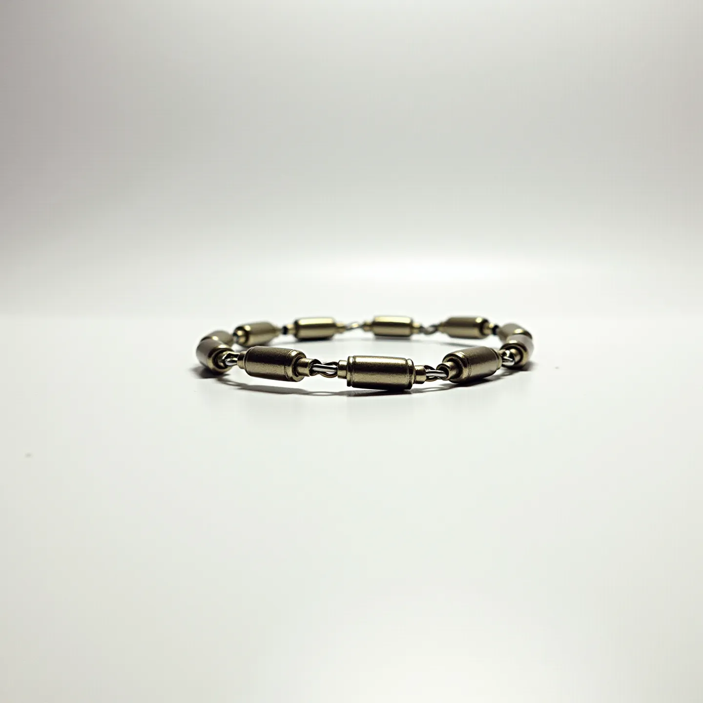 This ankle bracelet is composed of metallic cylindrical beads interspersed with small connector links. The beads are oblong and appear to be crafted from a metal with a smooth finish, providing a sleek and modern aesthetic. There are no gemstones or additional adornments set into the metallic components. The bracelet is designed to be flexible, allowing it to comfortably encircle the ankle. The connection between the beads is likely formed by sturdy wire or small metal links, ensuring durability and ease of wear. Overall, the bracelet showcases a minimalist design with an emphasis on the uniform metallic elements.