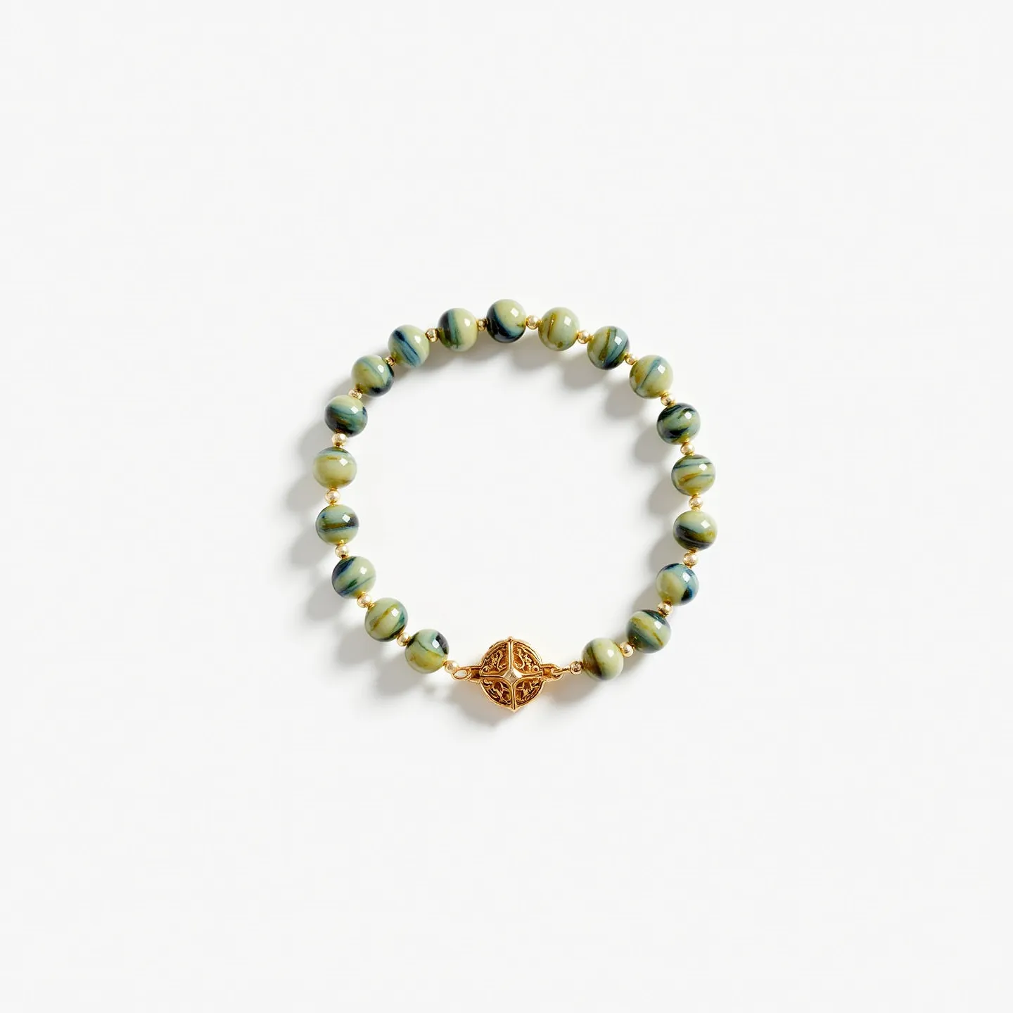 This baby bracelet features multicolored beads, predominantly in shades of green with blue and yellow hues, giving it a playful and vibrant appearance. The spherical beads are interspersed with small gold-toned spacer beads, adding a touch of elegance to the design. The centerpiece is an intricate round gold-toned charm with an ornamental, openwork pattern resembling a Celtic knot. The bracelet is stretchy and does not appear to have a traditional clasp, making it easy to slip on and off a baby's wrist.