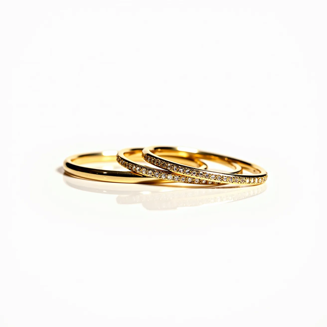 This bangles exude elegance crafted from a lustrous gold material, showcasing a timeless and classic appeal. The prominent feature of these bangles is the meticulous setting of small, sparkling gems along the outer surface, which appear to be round-cut diamonds. The gems are securely placed in a neat, pavé setting that adds a continuous shimmer to each bangle. These intricately designed bangles do not have visible clasps, suggesting that they are slip-on style, designed for ease and comfort. The harmonious combination of gold and diamonds results in a beautiful and luxurious accessory suitable for various occasions.