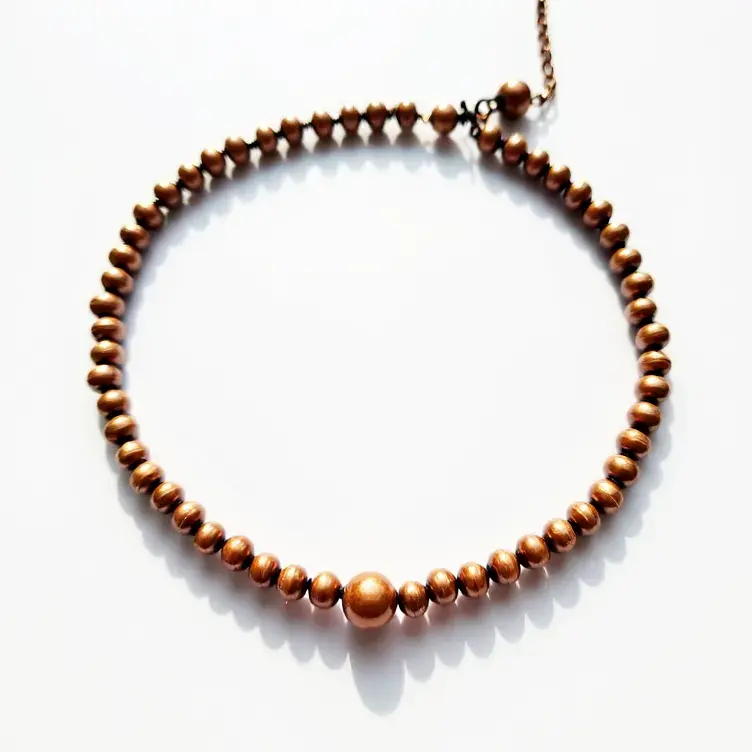 This beaded bracelet features a series of evenly spaced, rounded beads with a metallic copper finish, creating a uniform and cohesive design. The central bead is slightly larger than the surrounding beads, adding a subtle focal point to the piece. The bracelet closes with a secure lobster clasp, attached to an adjustable chain, allowing for a customizable fit. The polished surface of the beads gives the bracelet a touch of sophistication and elegance, making it suitable for both formal and casual wear.