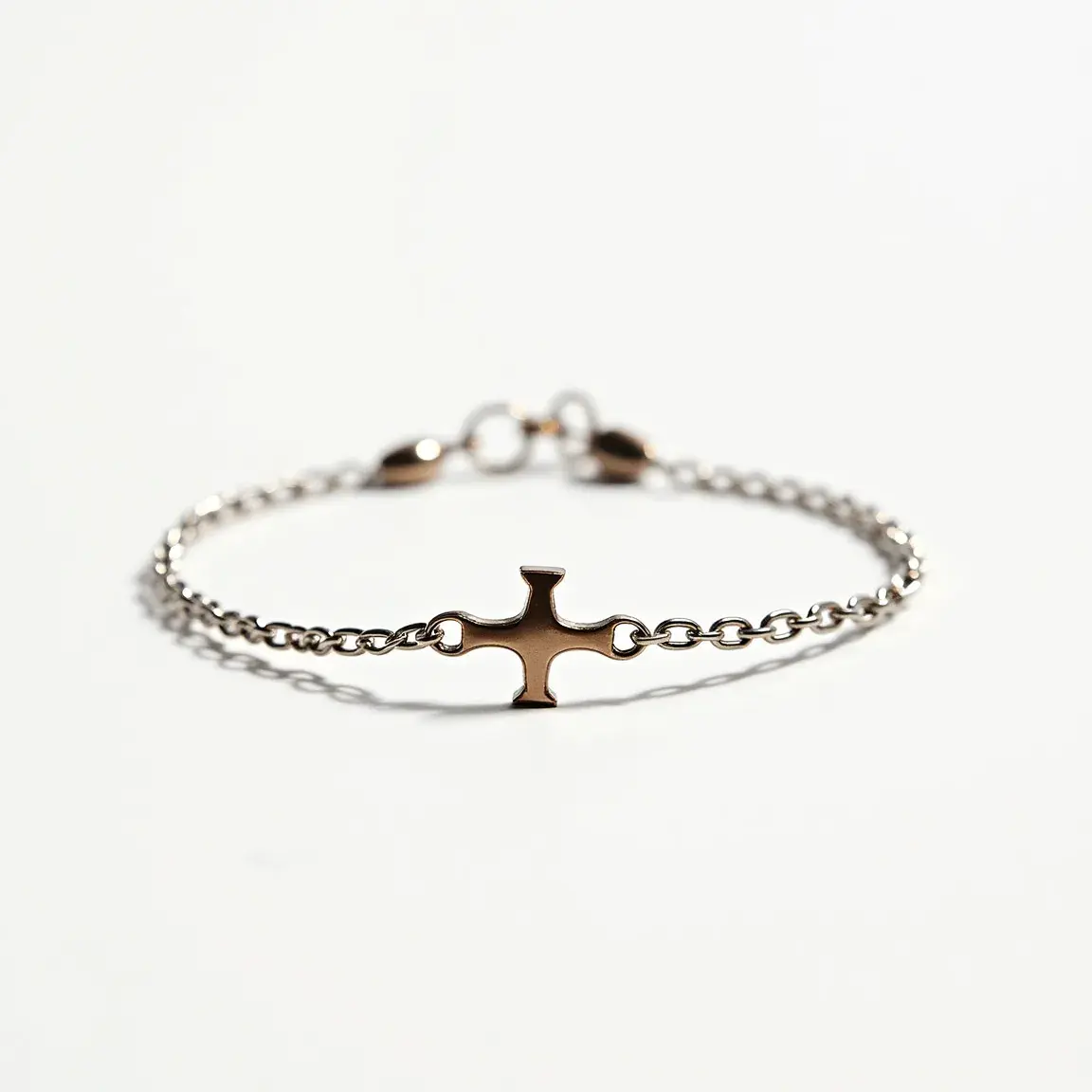 This cross bracelet features a central cross-shaped charm that is attached to a delicate, fine chain. The cross appears to be made of a shiny, metallic material with a smooth finish, likely gold or gold-plated. The bracelet's chain is composed of small, uniformly sized links, also crafted from a similar metallic material, possibly stainless steel or vermeil. The bracelet is secured with a lobster clasp, providing a reliable and secure attachment. The minimalist design allows the cross charm to be the focal point of the bracelet, creating a simple yet elegant piece of jewelry.