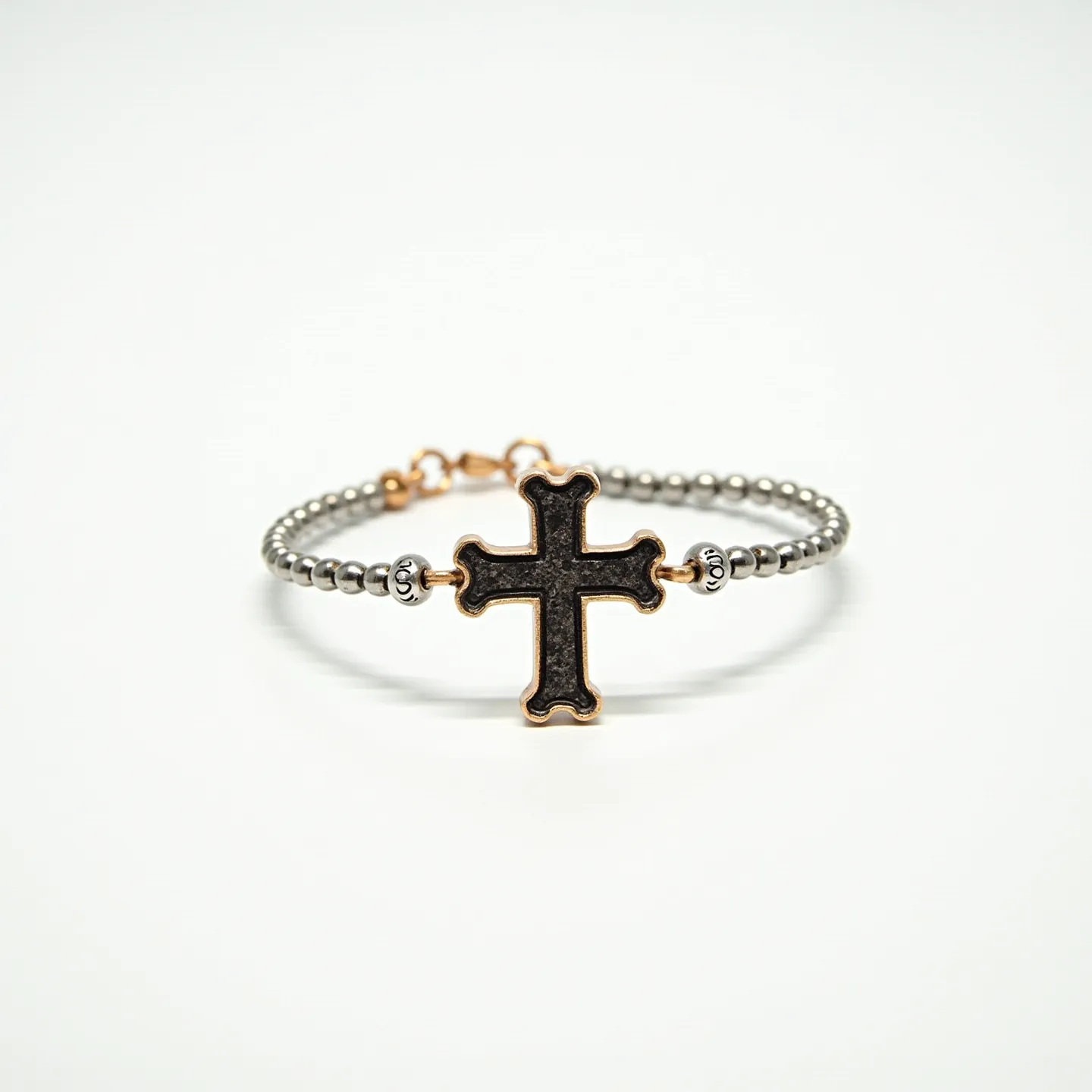 This cross bracelet features a linked chain composed of metallic beads, possibly made from stainless steel or silver. At its center is a stylized cross with an ornate design, which appears to be crafted from a dark-toned material encased in a gold or brass setting, adding a touch of contrast and elegance. The cross is further accentuated by two decorative roundels on either side, which seamlessly integrate into the overall beaded chain design. The bracelet is secured with a clasp mechanism, ensuring a firm and reliable attachment when worn.