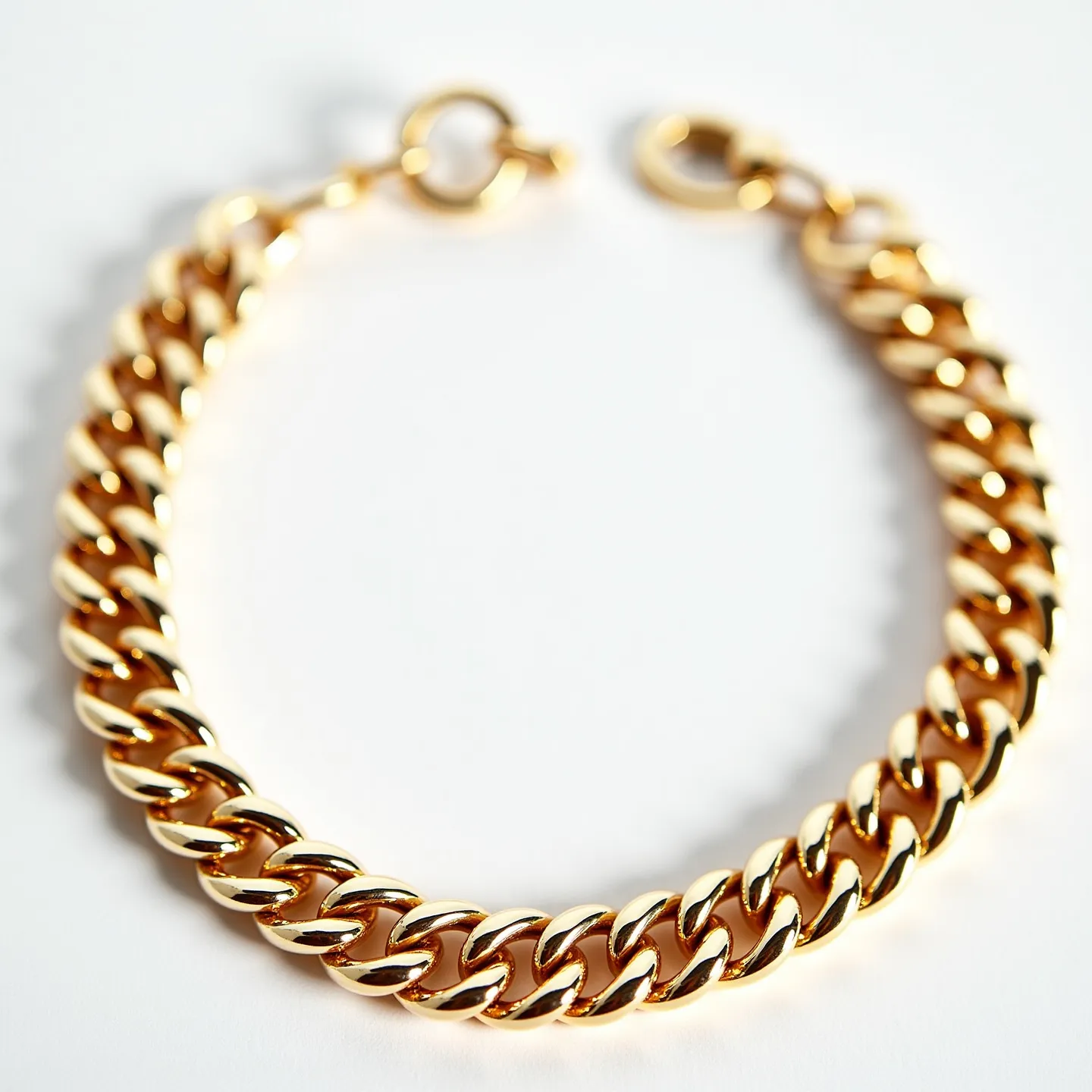 This Cuban link bracelet showcases a series of uniform, interlocking links crafted from what appears to be gold, giving it a bold and luxurious appearance. The links are polished to a high shine, enhancing the bracelet's visual appeal and adding a touch of elegance. The bracelet features a round ring clasp for secure attachment, ensuring it stays fastened while worn. The design is both classic and stylish, making it a versatile accessory suitable for various occasions.