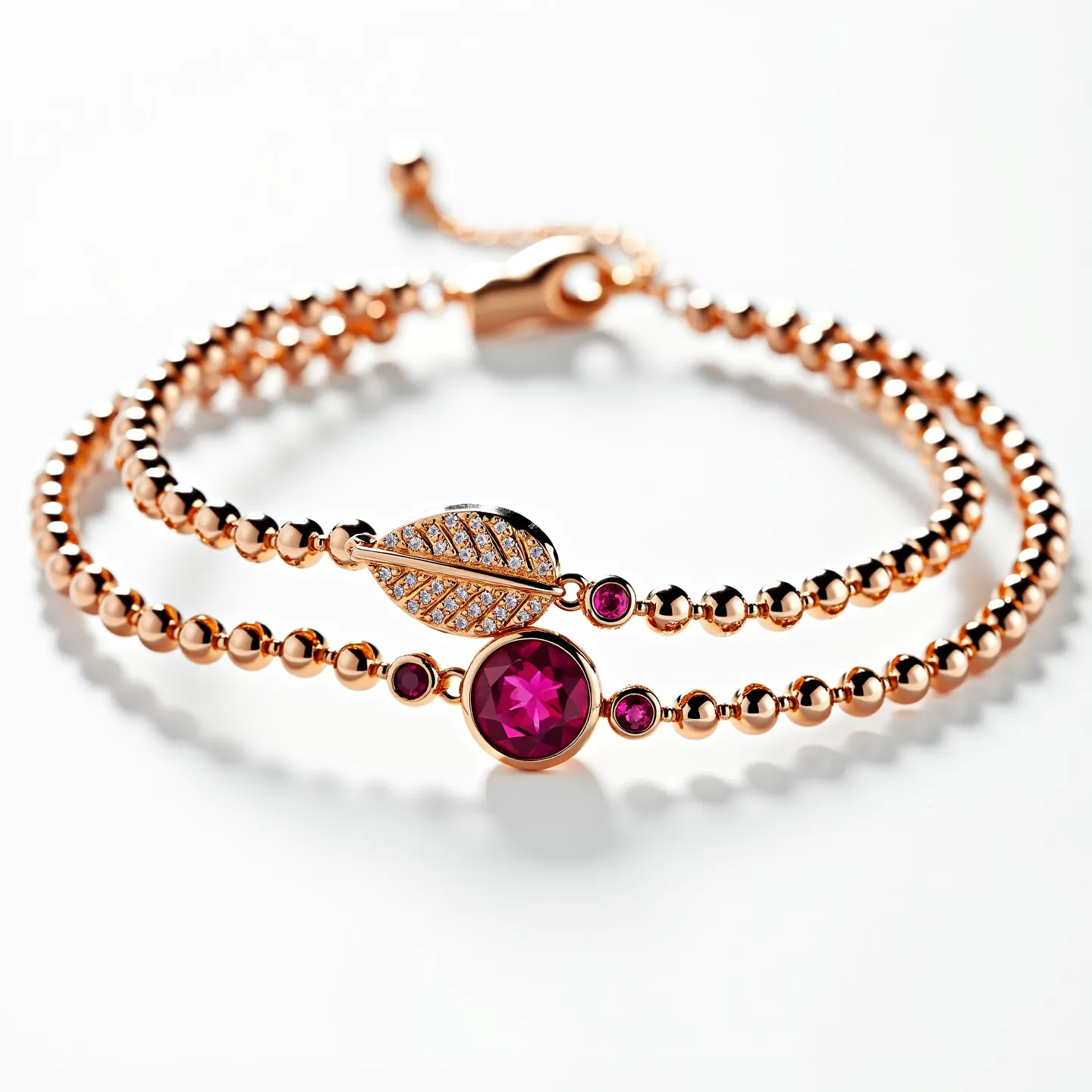 This gold beaded bracelet features a delicate arrangement of polished gold beads, interspersed with a striking array of gems. It highlights a central deep red, round-cut gemstone in a bezel setting, flanked by smaller matching red stones. Additionally, the bracelet incorporates a leaf-shaped charm adorned with a series of small, sparkling white stones in a pave setting. The bracelet is secured with an adjustable slider clasp, enhancing both its elegance and functionality.