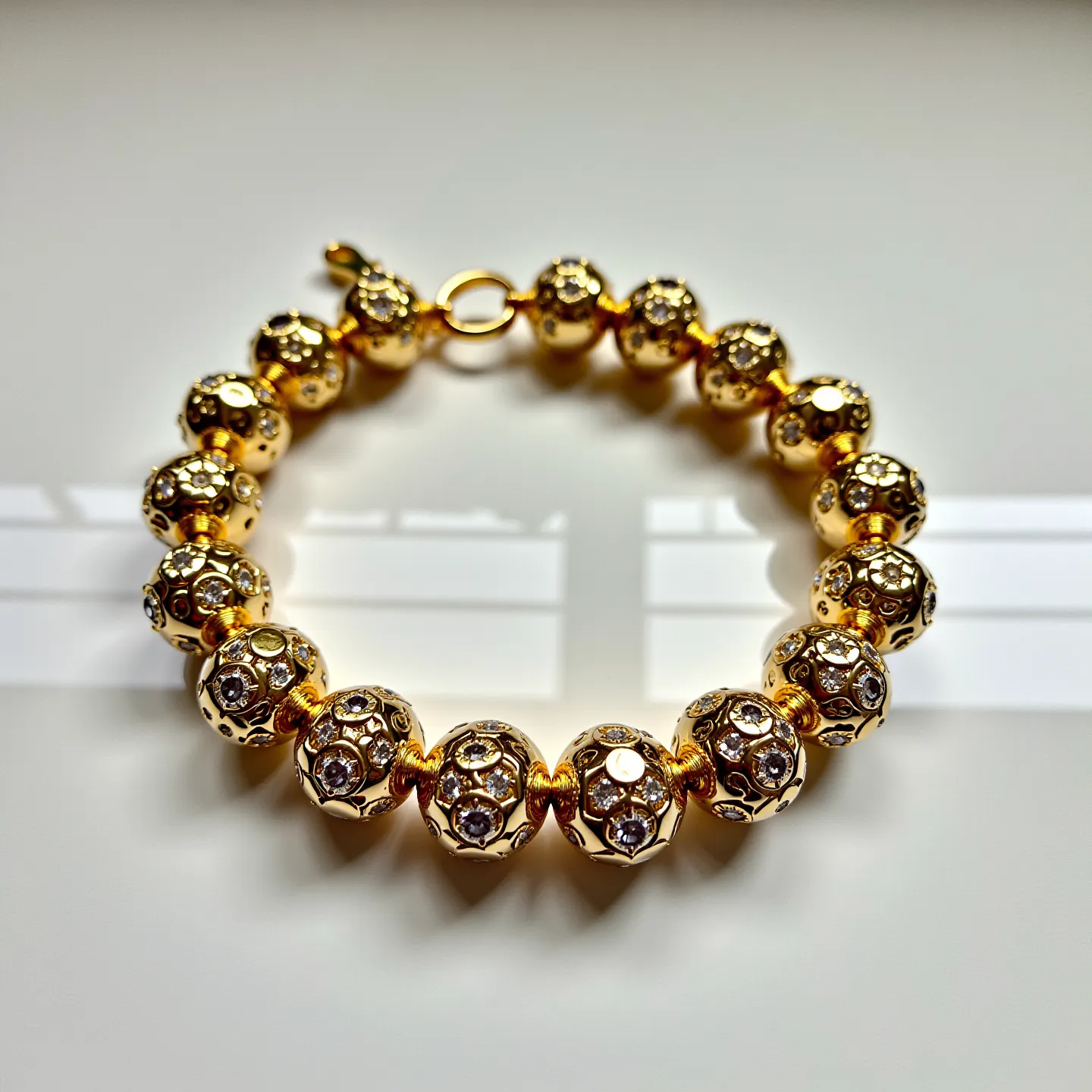 This gold beaded bracelet features spherical beads, each exhibiting a lustrous gold finish interspersed with clear, faceted gems embedded throughout. The gems are likely cubic zirconia or small diamonds, adding an elegant sparkle to the bracelet. Each bead is separated by a small, gold spacer to enhance flexibility and fluid movement when worn. The clasp adheres to a simple but secure design, with a lobster claw mechanism that connects to a circular ring, ensuring ease of use and secure wearability.