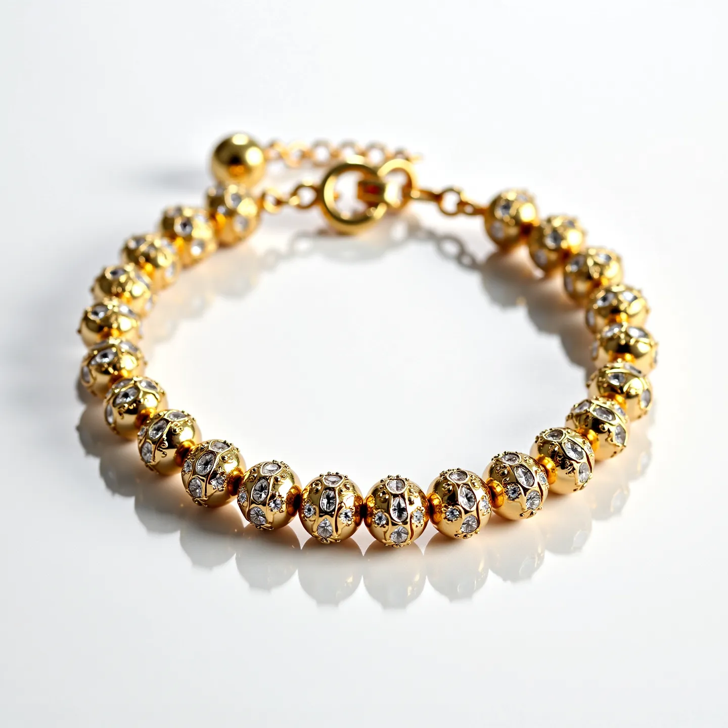 This gold beaded bracelet features round beads that are meticulously crafted from gold. Each bead is adorned with small, clear gemstones set in a intricate pattern around the surface. These gemstones appear to be round cut and are securely embedded within the gold beads, adding a touch of sparkle and elegance. The bracelet is finished with a gold-colored lobster clasp and an extender chain, allowing for an adjustable fit and secure wearing experience.