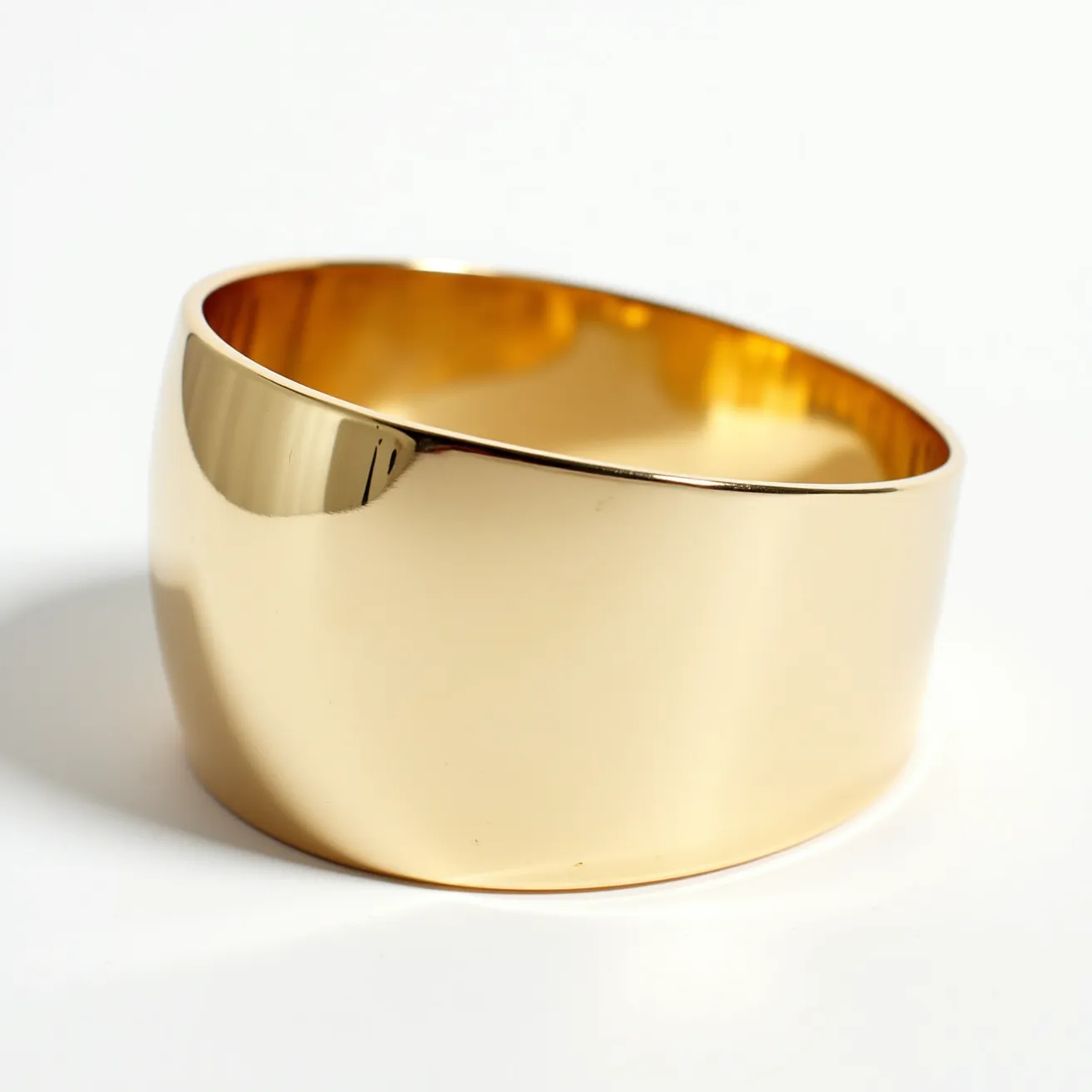 This gold cuff bracelet features a smooth and polished surface, crafted entirely from gold. The design is simple and elegant, without any gemstones or intricate patterns. The cuff style allows for a comfortable fit around the wrist, with a slightly tapered shape that adds to its sophisticated look. There is no visible clasp or attachment, as the bracelet's form is designed for easy slip-on wear. The lustrous finish enhances its luxurious appearance, making it a versatile accessory for various occasions.