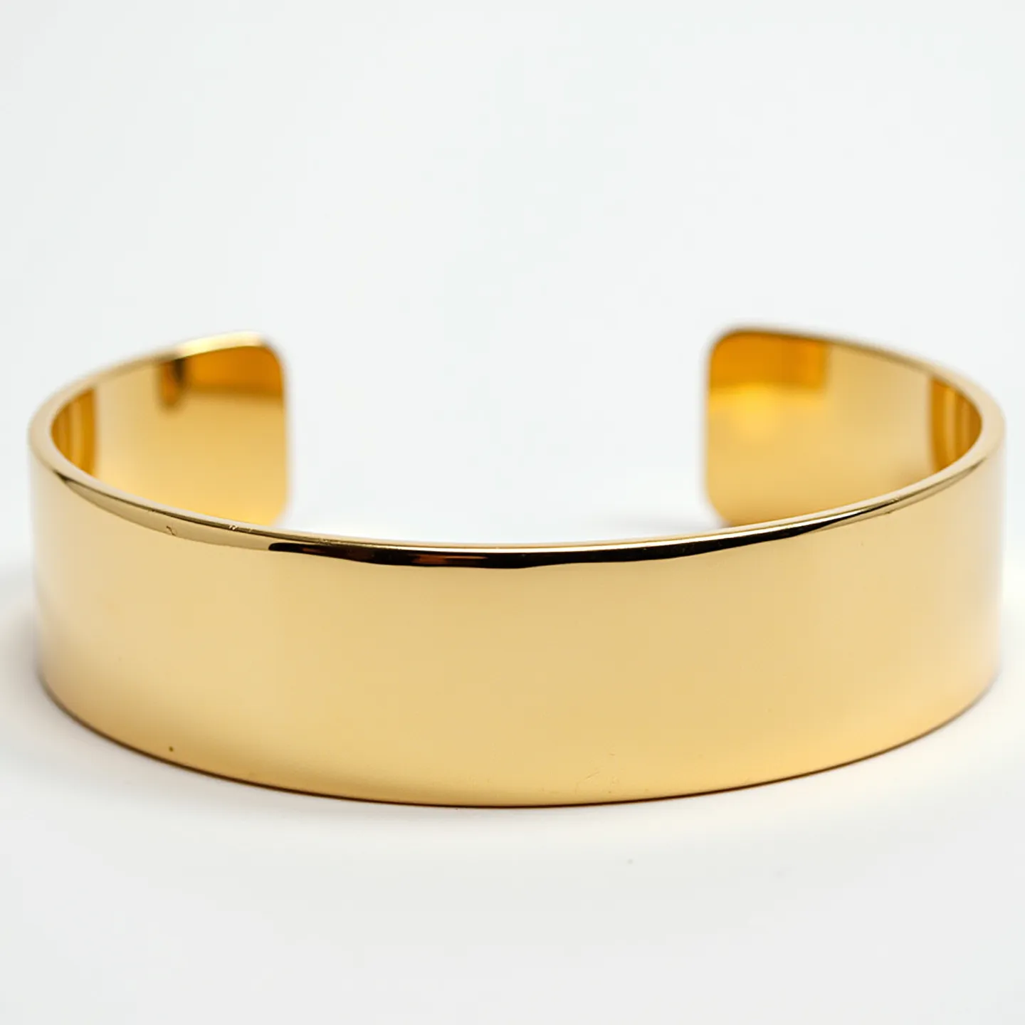 This gold cuff bracelet features a smooth, polished surface that showcases the lustrous quality of the metal. The bracelet is crafted from a rich, yellow gold, giving it a classic and elegant appearance. There are no visible gemstones or additional decorative elements on its sleek, continuous band. The open-ended design of the cuff allows for easy wearing and removal, providing a secure yet adjustable fit around the wrist. The simple yet refined styling of this bracelet makes it a versatile accessory suitable for any occasion.