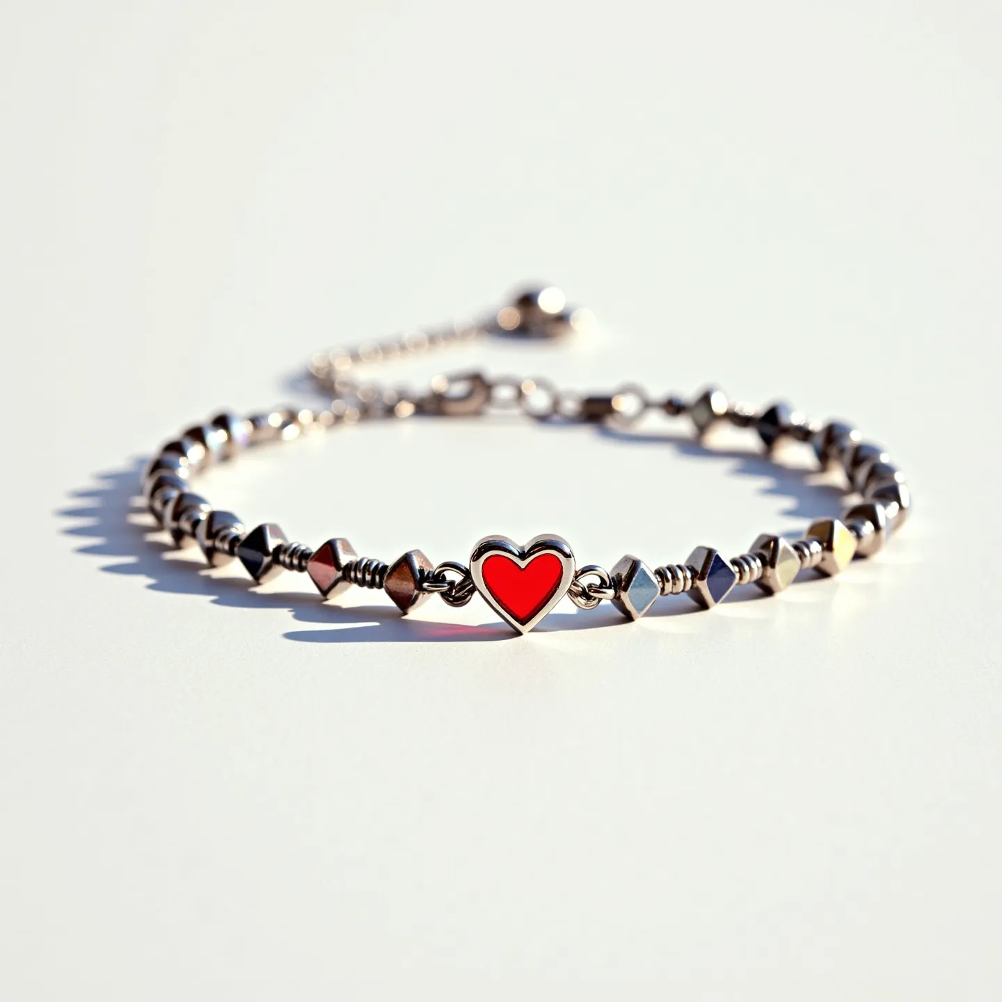 This heart bracelet showcases a charming design featuring a prominent heart-shaped centerpiece. The heart is encased in a metal setting and filled with a vibrant red enamel, adding a pop of color to the piece. The bracelet itself is composed of a series of metal beads, which seem to be primarily geometric in shape, potentially including hexagonal or polygonal forms. These beads are strung together in a symmetrical pattern, contributing to the bracelet's overall aesthetic. Additionally, the bracelet includes a fine metal chain with a bead at the end, suggesting it may feature an adjustable sliding clasp for secure and comfortable wear.