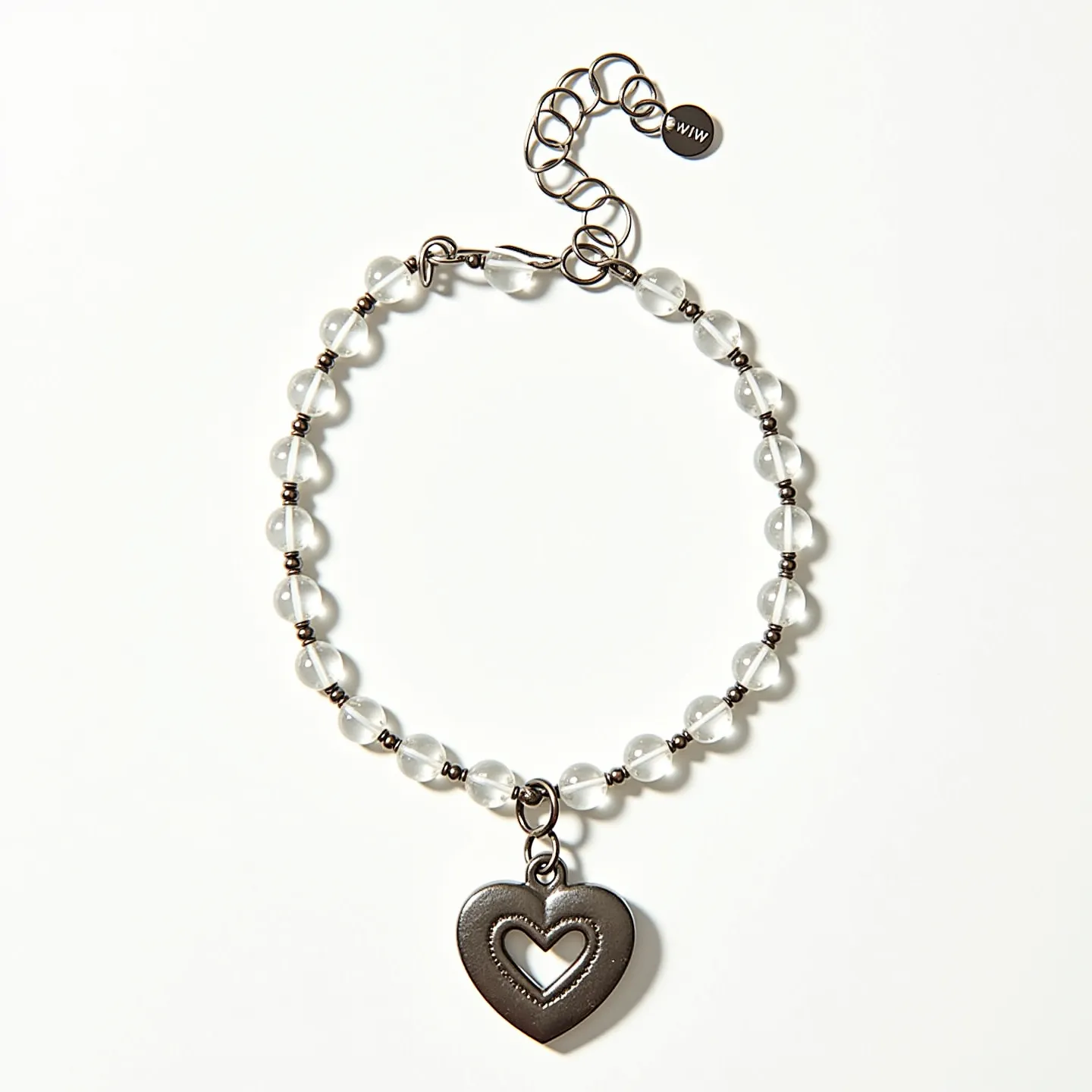 This heart bracelet features a series of translucent round beads, likely made of glass, connected by metal links. Each bead is separated by small metal spacer beads, adding a touch of contrast and elegance to the design. Dangling from the bracelet is a metallic heart pendant with an inner heart cut-out, creating a layered and textured feel. The bracelet is secured with an adjustable chain and a lobster clasp, providing ease of wear and the ability to customize the fit.