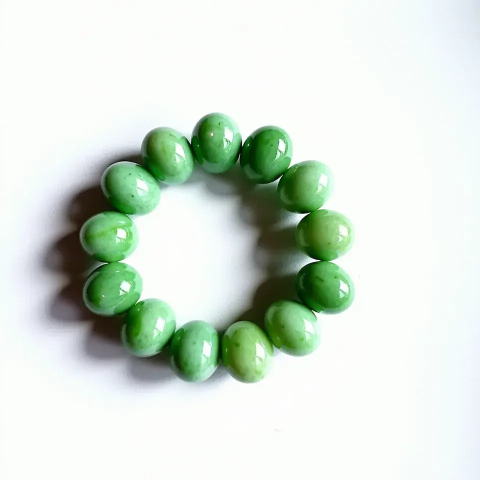 This jade bracelet features a collection of polished, translucent green jade beads. Each bead is smoothly rounded and evenly sized, showcasing the vivid green hues typical of quality jade. The bracelet appears to be strung on an elastic cord, allowing for easy wear and removal without the need for a clasp or additional attachments. The jade beads, with their natural variations in color, contribute to the overall aesthetic of the bracelet, making it a visually appealing piece.