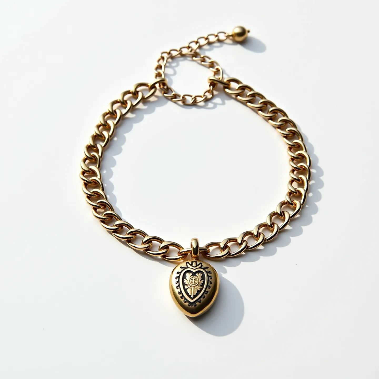 This locket bracelet is crafted from polished gold-toned metal, showcasing a sturdy, interconnected chain design that lends a classic and elegant appeal. At its center hangs a heart-shaped locket with intricate engravings and scrollwork that adds a touch of vintage charm. The locket is suspended from a small solid loop. The bracelet features an adjustable length courtesy of its extended link chain and is secured with a ball-and-loop clasp that ensures both functionality and style.