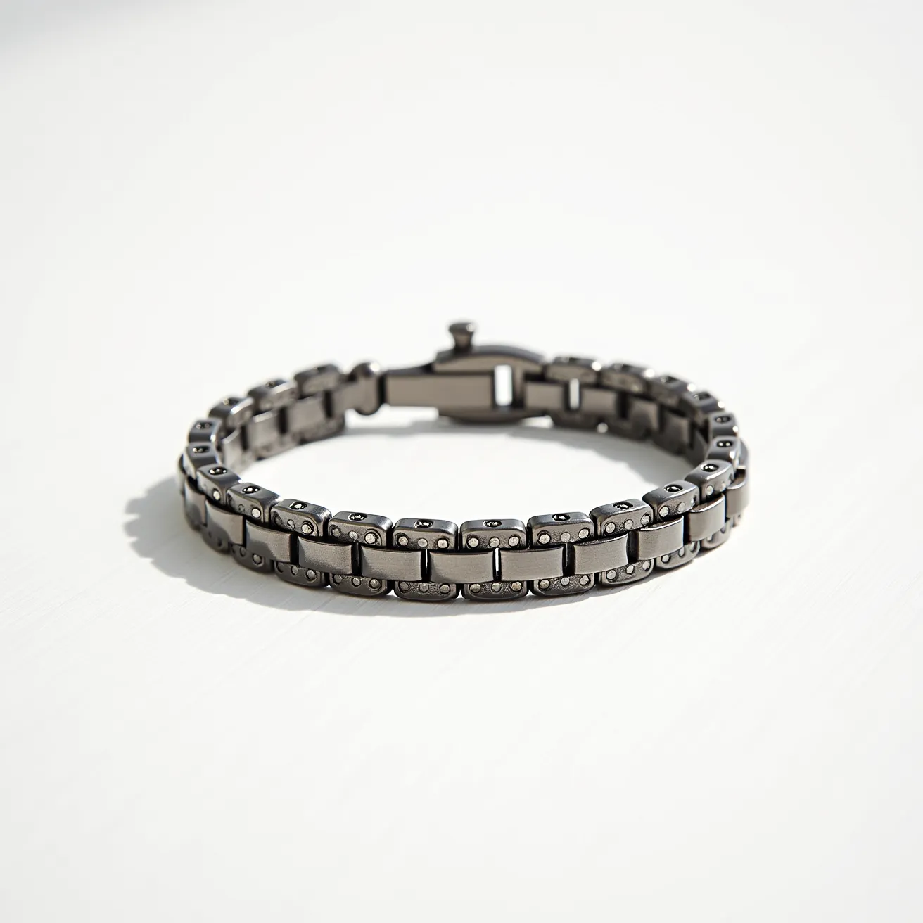 This men's bracelet features a sleek, modern design crafted from high-quality metal links, likely stainless steel. The links are rectangular and have a brushed finish, giving them a refined yet understated appearance. The bracelet is composed of two parallel rows of these links, connected by smaller metal pieces, creating a sturdy and flexible structure. It utilizes a clasp mechanism that ensures a secure fit on the wrist. The clasp appears to be of fold-over style, blending seamlessly with the rest of the bracelet. No additional gems or stones are present, maintaining a minimalist and industrial aesthetic.