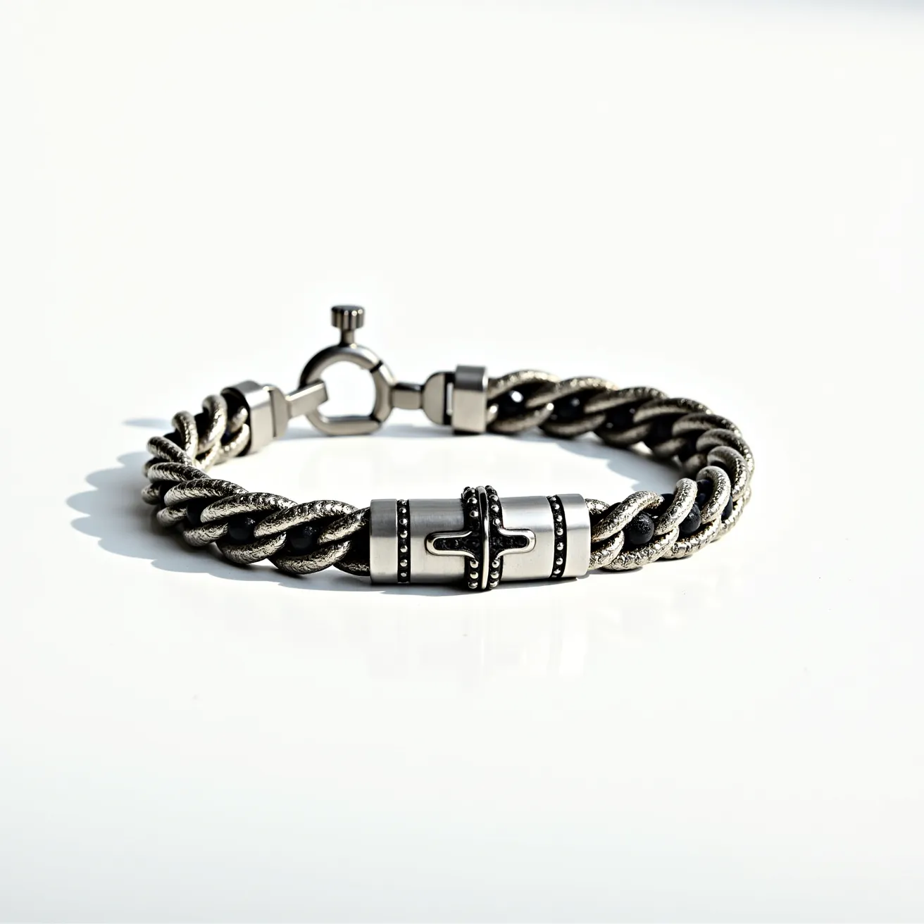 This men's bracelet features a robust and stylish design, crafted primarily from a metallic material with a braided rope texture. The central section of the bracelet showcases ornamental cylindrical bead accents, which might be made of stainless steel or a similar durable metal, adorned with a polished finish and intricate, dark oxidized detailing. The bracelet is equipped with a toggle clasp mechanism consisting of a loop and a bar, ensuring a secure and easy-to-use closure. The overall aesthetic is modern and rugged, suitable for everyday wear.