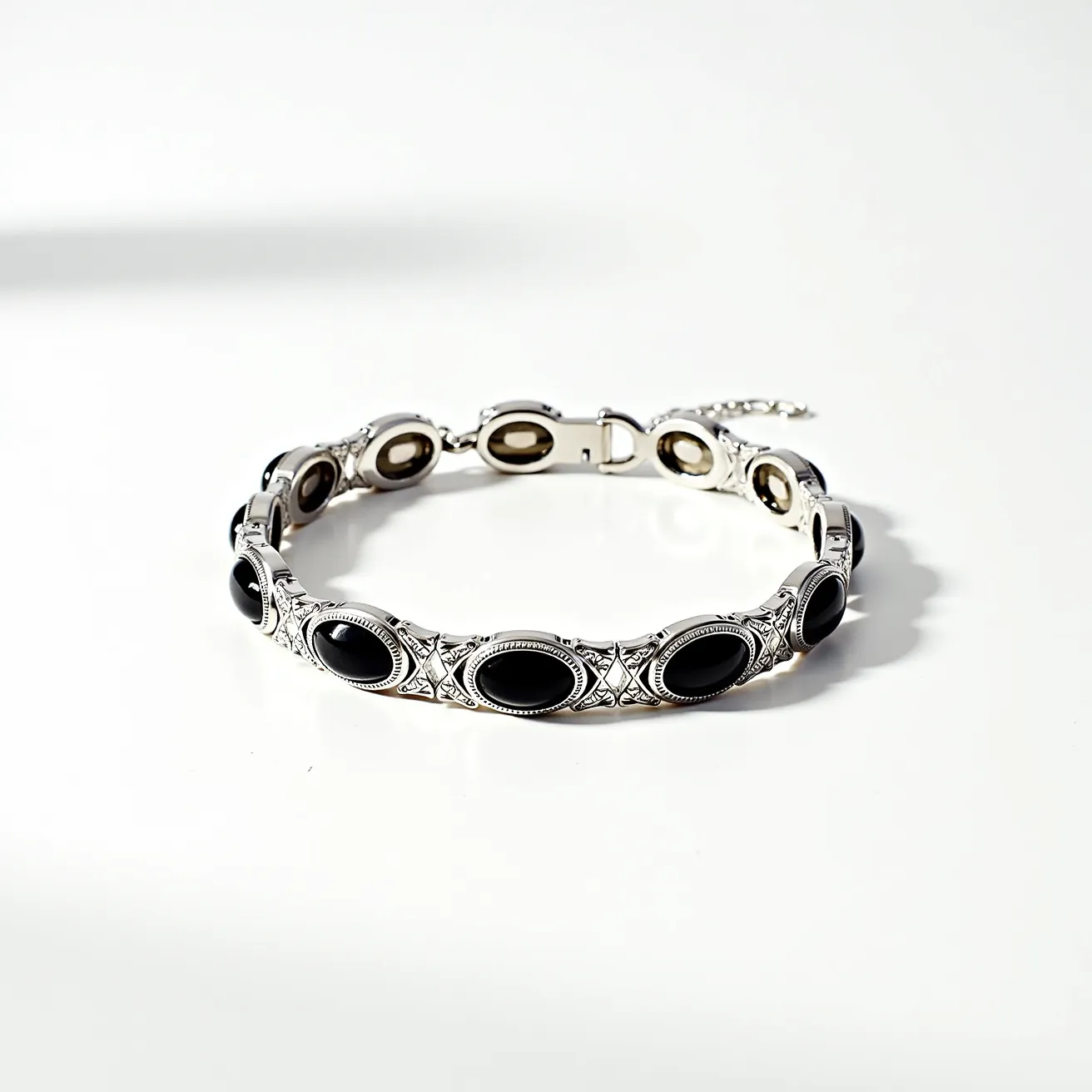 This men's bracelet features a series of oval black stones, each meticulously set into a metallic base with intricate detailing. The stones are smooth and polished, presenting a high-gloss finish that contrasts elegantly with the ornate design of the metal. The bracelet is segmented, allowing for flexibility and a comfortable fit. It is secured with a sturdy clasp that ensures it stays fastened when worn. The combination of the dark stones and the detailed metal work creates a sophisticated and timeless accessory.