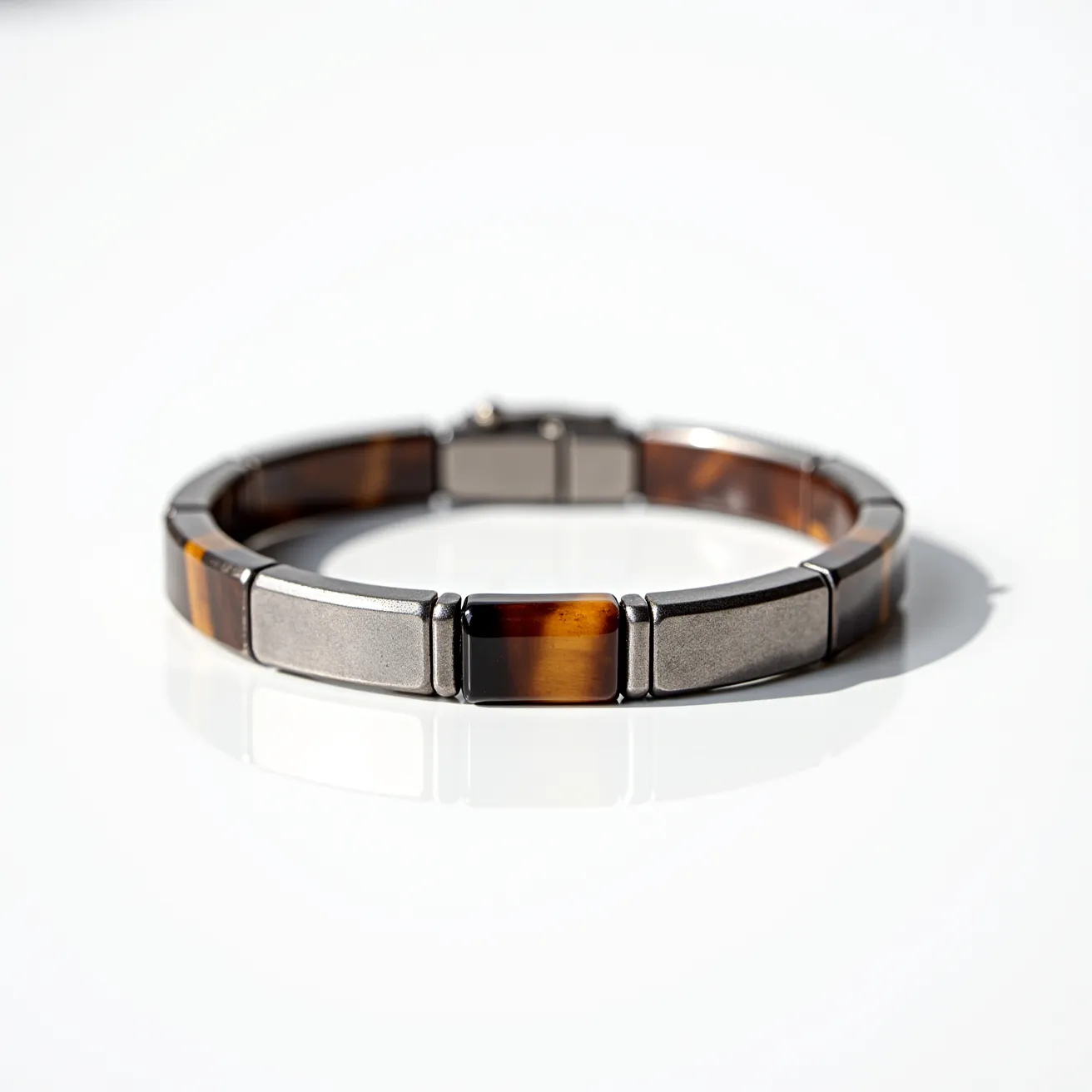 This men's bracelet features a combination of sleek, metallic segments interspersed with rectangular pieces of tiger's eye gemstone. The polished metal segments provide a high-contrast complement to the rich, amber, and brown hues of the tiger's eye stones, which are cut into uniform rectangular shapes and set in a seamless, flush manner with the metal links. The clasp is an integrated, fold-over style that ensures a secure and comfortable fit, maintaining the bracelet's sleek and coordinated design.