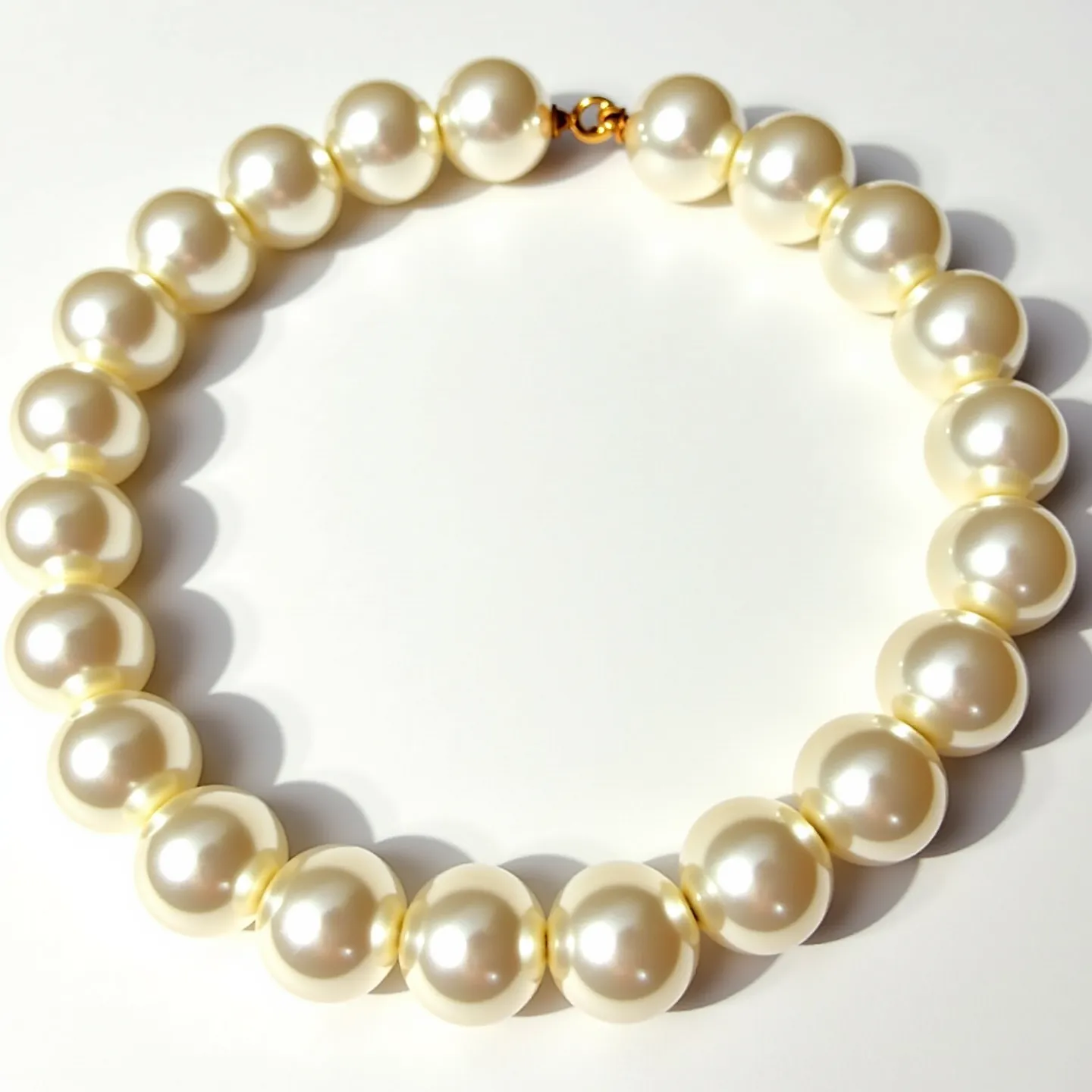 This pearl bracelet features a string of uniformly sized, round, white pearls exhibiting a lustrous surface. The pearls are closely strung together, creating a seamless and elegant appearance. The bracelet is secured with a small, round clasp that appears to be made of a gold-toned metal, adding a touch of warmth to the overall design while ensuring a secure fit. The harmonious arrangement and high-quality materials make this bracelet a timeless and sophisticated accessory.