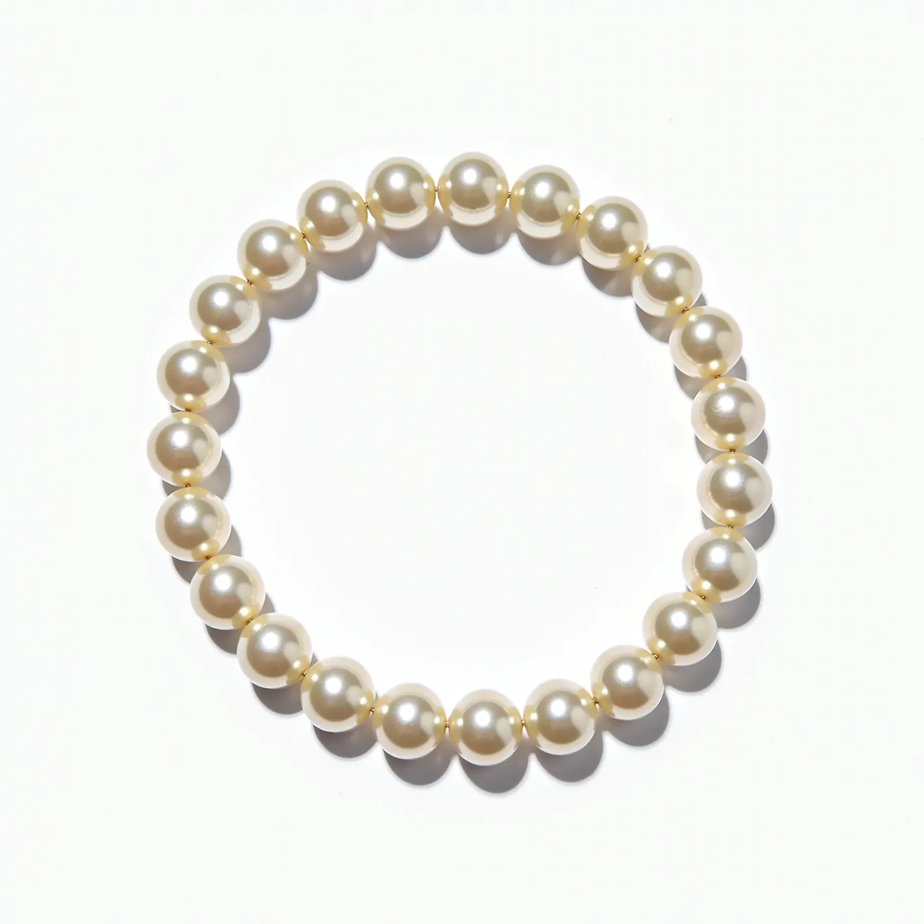 This pearl bracelet features a series of uniformly sized, lustrous white pearls. Each pearl is spherical and well-matched in both color and size, creating a harmonious and elegant appearance. The pearls are strung closely together on a stretchy band, allowing the bracelet to be easily slipped on and off without the need for a traditional clasp. This stretch band design provides both style and convenience, ensuring a secure and comfortable fit on the wrist. The simple, yet classic design of this bracelet makes it a versatile accessory suitable for a variety of occasions.