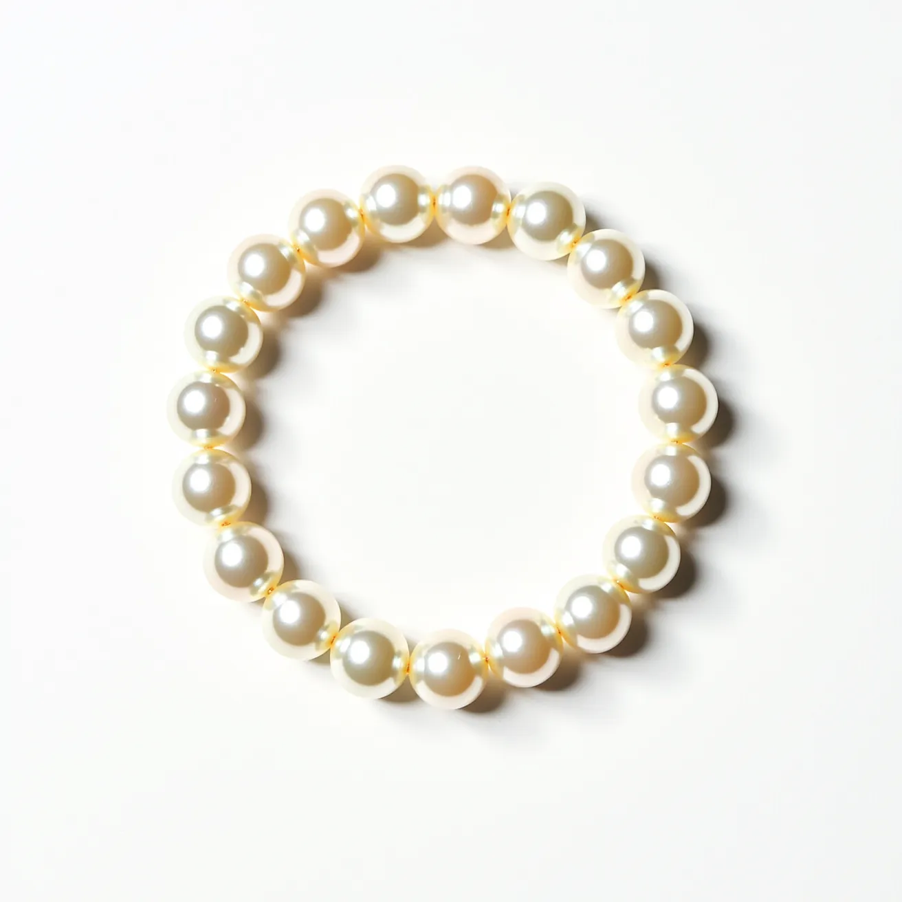 This pearl bracelet features a series of lustrous, round pearls, each one seamlessly strung together. The pearls are uniform in size and exhibit a smooth, polished surface that reflects light beautifully. The bracelet does not appear to include any additional gems or stones. It is designed as a continuous strand, likely with an elastic or hidden connector mechanism, ensuring a sleek and seamless appearance.