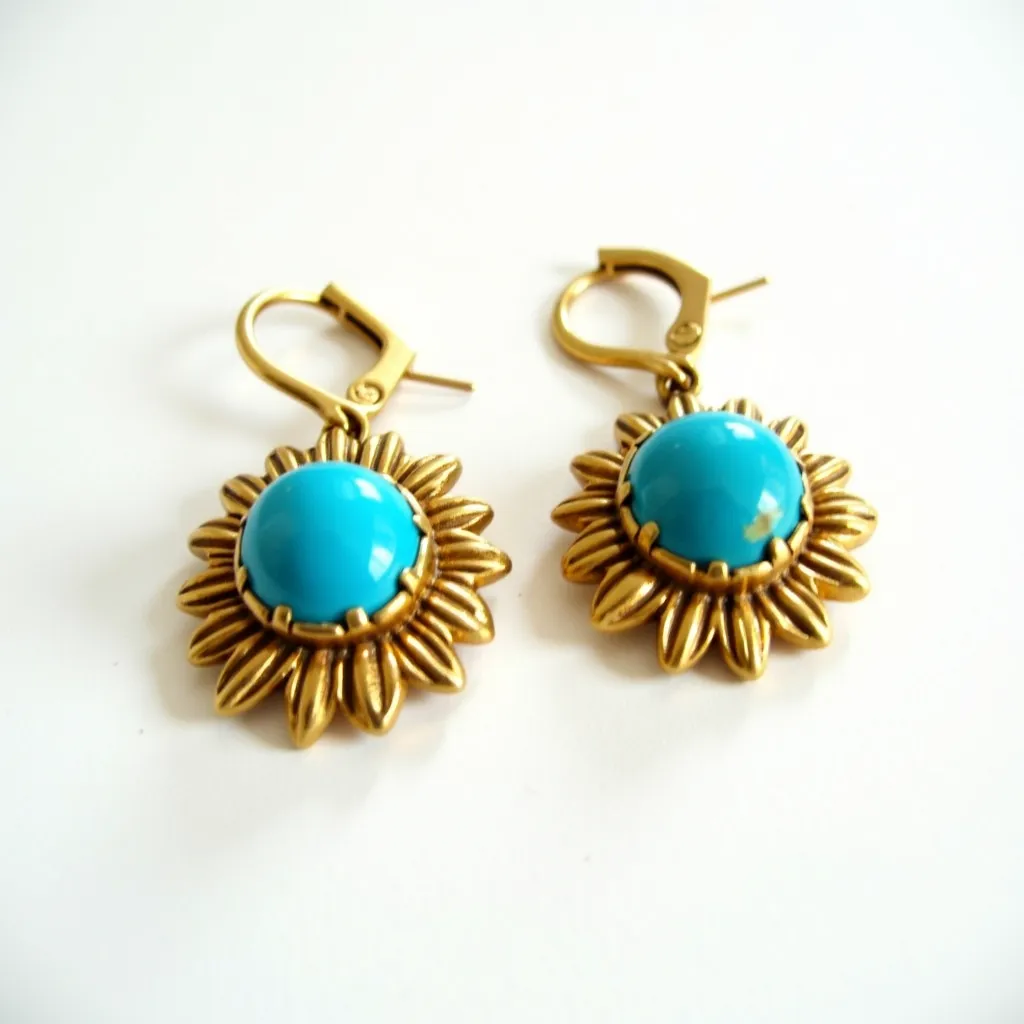 These 70s earrings feature a vibrant turquoise cabochon set at the center, surrounded by a gold-tone floral design reminiscent of a sunflower. The turquoise stones are polished and smoothly cut, reflecting the era's trend toward bold and colorful statement pieces. The gold-tone metal setting adds a vintage charm, highlighting the vivid blue of the stone. These earrings have a lever-back clasp, ensuring a secure attachment when worn. The overall design is playful yet elegant, capturing the eclectic and expressive style of the 1970s.