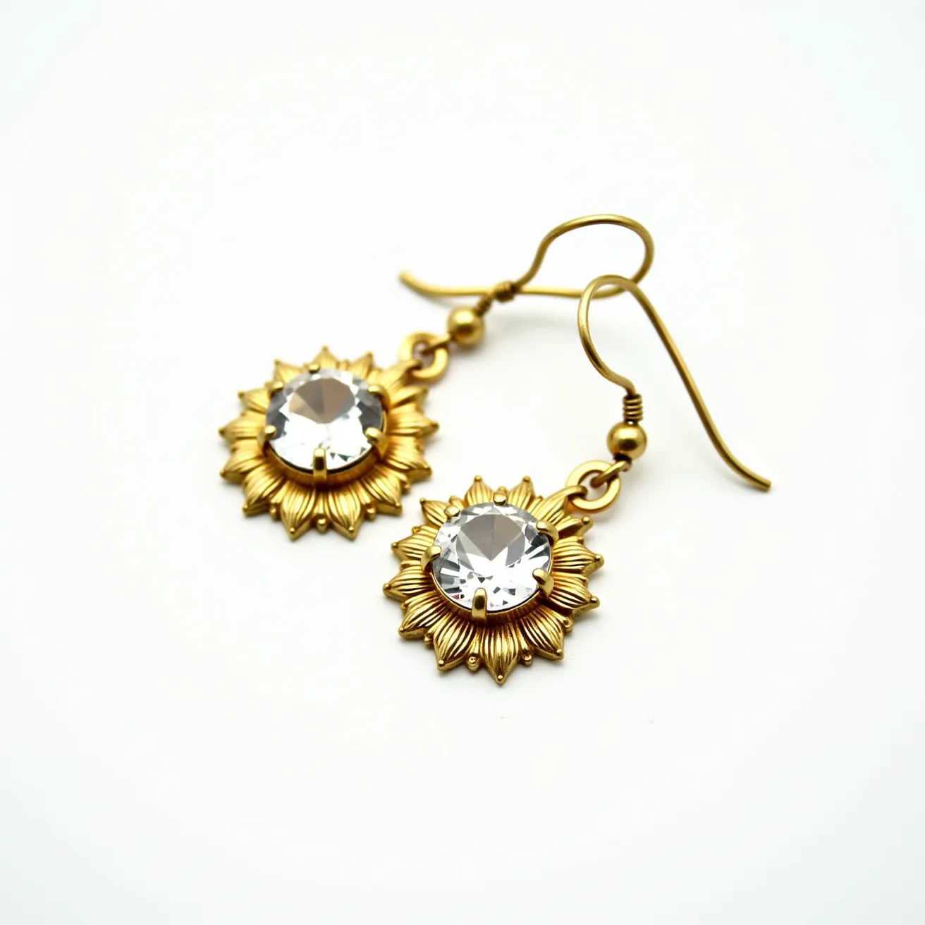 These 70s earrings showcase a vibrant gold-toned metal crafted into a sunflower design, with a large, round faceted gem set at the center, secured in a bezel-like setting. The gem’s clear brilliance contrasts beautifully against the warm metallic petals, enhancing the piece’s retro elegance. The earrings are designed with a classic and practical fishhook clasp, ensuring easy attachment and removal. The intricate detailing of the metalwork highlights the era's appreciation for bold and expressive fashion statements.