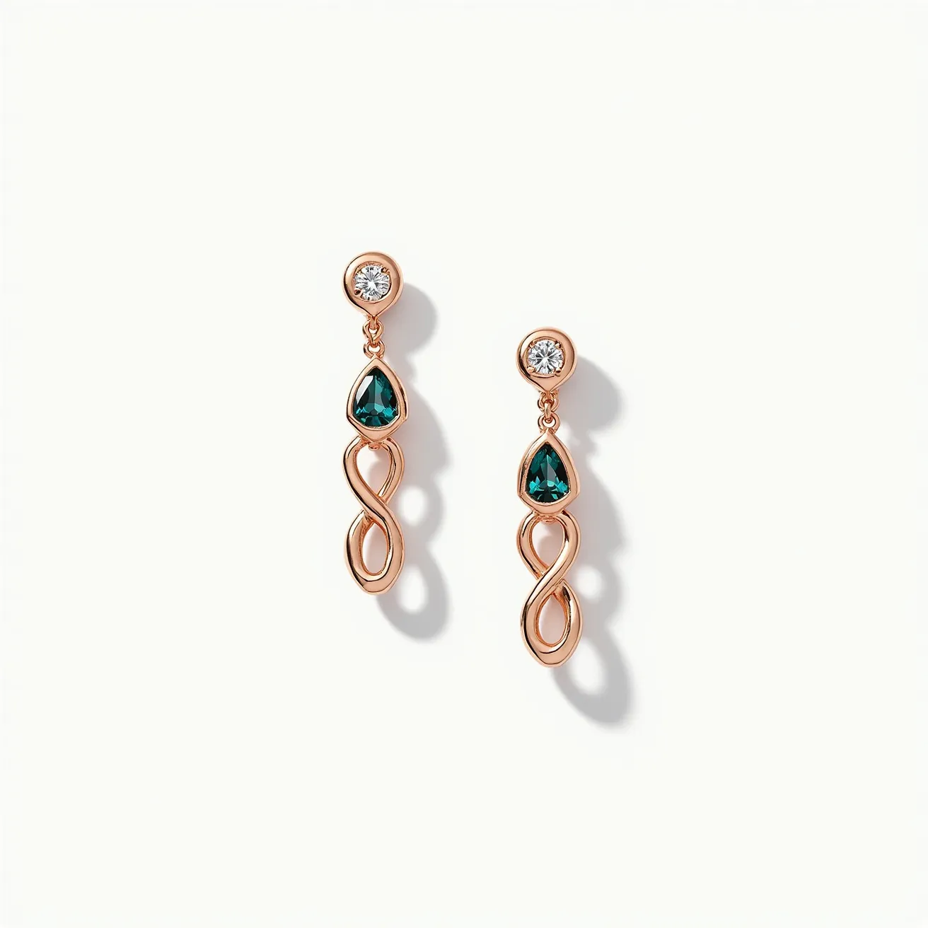 These birthstone earrings feature a stunning combination of materials and gems set in a rose gold metal. At the top, a round cut diamond is bezel-set, providing a sparkling accent. Below, a pear-shaped green gemstone, likely an emerald indicative of a May birthstone, is elegantly nestled in a secure setting. The earrings flow into an elegant looping design, adding a touch of sophistication and fluidity. The attachments suggest a secure, traditional post-back clasp, which ensures ease of wear and stability.