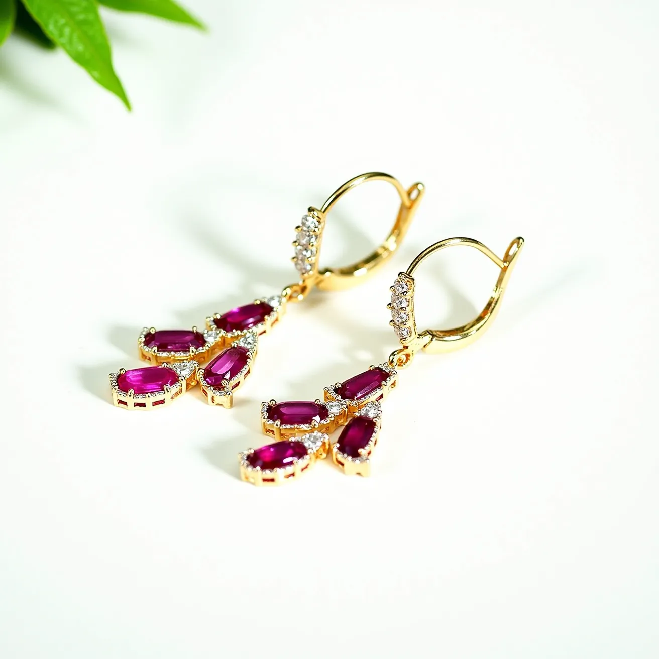 These birthstone earrings feature a striking design with vibrant marquise-cut stones, likely rubies, that exhibit a rich, deep red hue. Each stone is surrounded by a halo of small, round brilliant-cut clear stones, enhancing their vivid color and adding a touch of sparkle. The stones are set in a warm gold-toned metal, which provides a beautiful contrast and complements the red of the birthstones. The earrings are attached with a secure lever-back clasp, offering both elegance and functionality. The overall design is sophisticated and eye-catching, making these earrings a stunning accessory for various occasions.