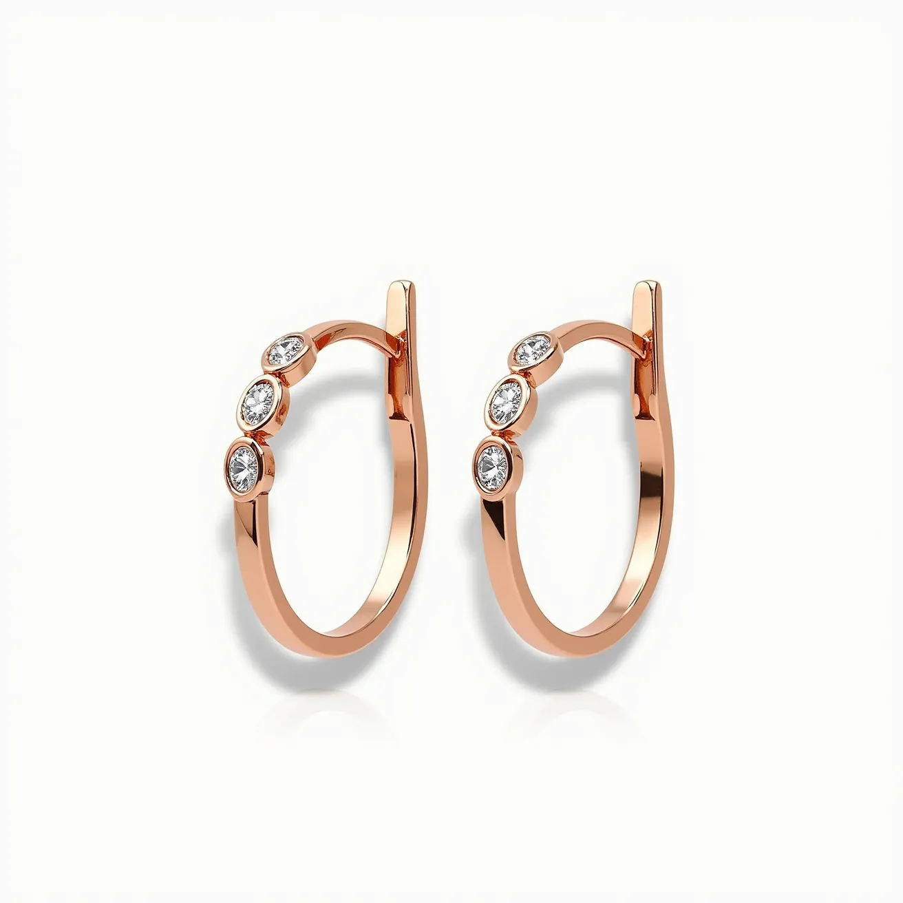 These cartilage hoop earrings showcase a sleek and elegant design crafted from a polished rose gold metal. Adorning the hoops are three round-cut gemstones, likely diamonds, set in a bezel setting that enhances their brilliance while ensuring security. The smooth curves of the hoops are complemented by a practical hinge or latch clasp mechanism, providing both style and functionality for easy wear.