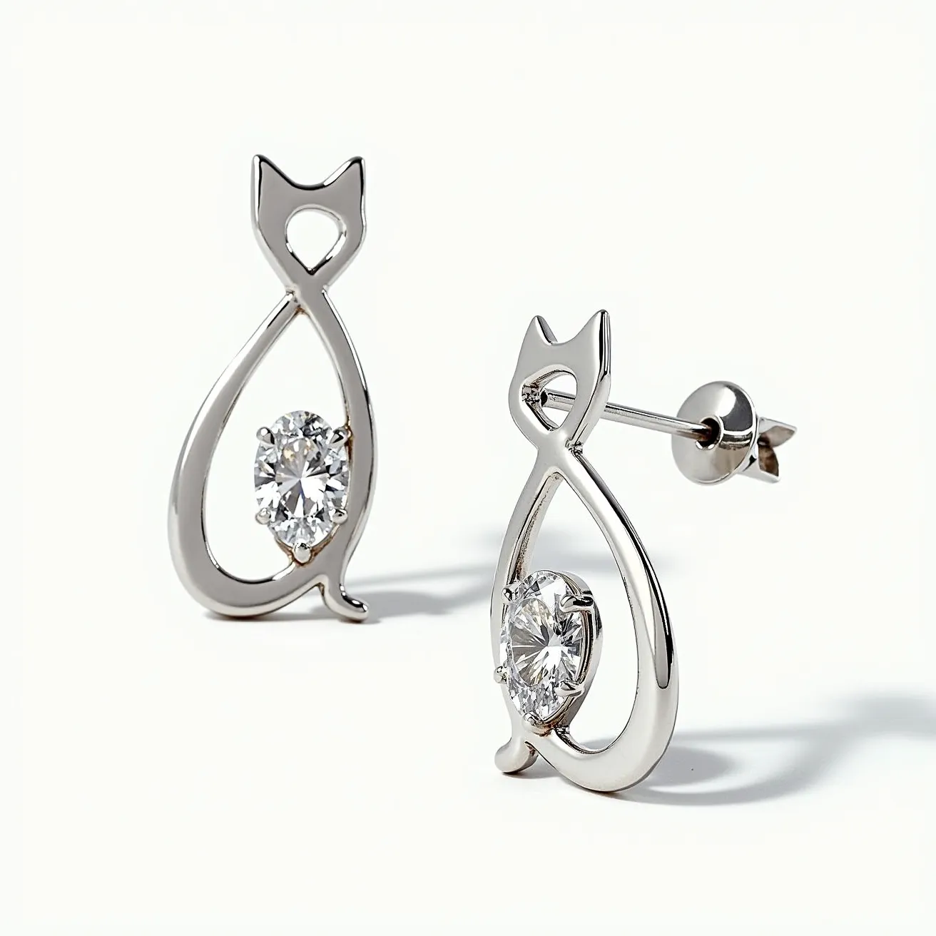 These cat earrings feature a sleek metallic design shaped like a stylized cat outline, incorporating a prominent round-cut stone at the center, likely a clear gemstone or crystal. The gemstone is set in a simple, minimalistic prong setting, enhancing its visibility and sparkle. The main body of the earrings appears to be crafted from a polished metal, possibly silver or white gold, lending a smooth and reflective finish. Each earring is secured with a post and butterfly clasp, making it easy to wear while ensuring stability when worn. These earrings balance whimsy and elegance, making them a charming accessory for everyday wear.