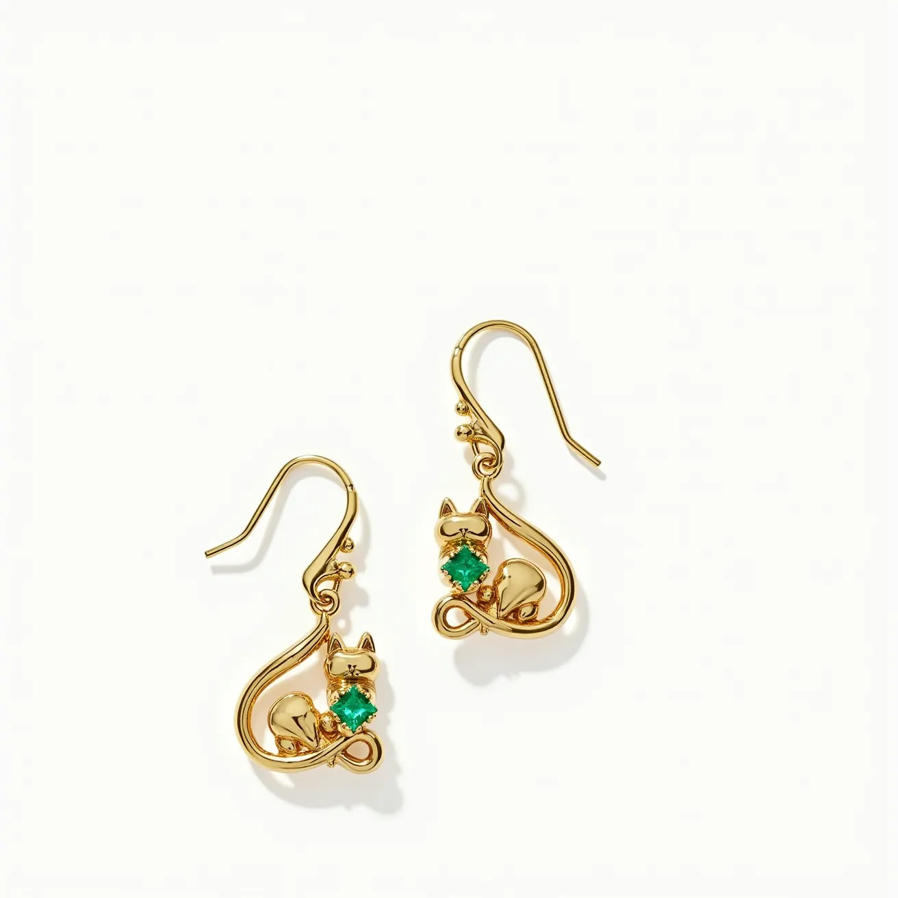 These cat earrings are crafted from gold-toned metal, featuring an elegant and whimsical design of a cat silhouette. Each earring showcases a vibrant green gemstone, likely an emerald or similar stone, in a square cut that adds a pop of color and sophistication to the design. The stones are set securely in a prong setting, highlighting their facets and brilliance. The earrings utilize a French hook attachment, offering both a classic aesthetic and ease of wear. The combination of the gold and green hues creates a captivating and playful accessory.