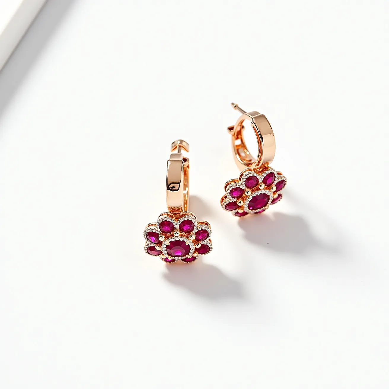 These clip on earrings feature a delicate floral design crafted from a gold-toned metal. Each earring displays an array of vibrant red gemstones set in a flower pattern. The stones are round and are nestled in a surrounded pave setting, enhancing their brilliance. The earrings are secured with a hinged back clasp, ensuring a comfortable and secure fit.