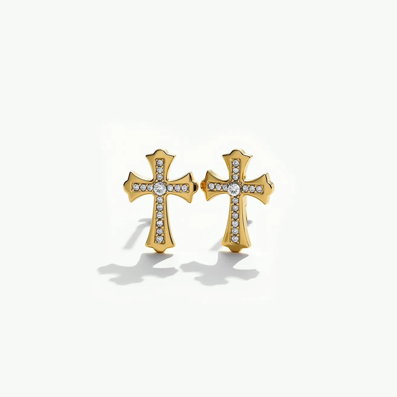 These cross earrings for women feature a luxurious gold-toned metal adorned with small, round-cut clear gemstones, likely cubic zirconia or diamonds, set in a pavé setting along the arms of each cross. The earrings have a larger central stone that appears securely set, enhancing the decorative design. The attachment mechanism is not visible, but they likely use a standard post and back closure, typical for stud earrings, to ensure ease of wear and stability. The combination of gold and sparkling stones gives them a classic and elegant appearance, suitable for various occasions.