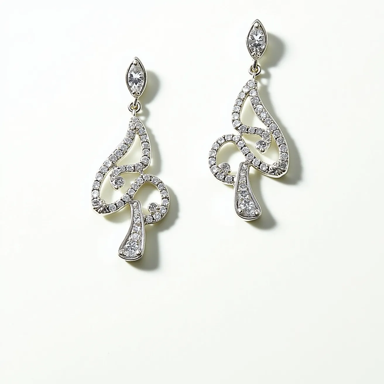 These dangle earrings feature an elegant design crafted from what appears to be a silver or platinum-like metal. The earrings are adorned with numerous small, round-cut gems, set closely together in a pave-style setting that follows a curving, abstract pattern. At the top of each earring is a marquise-shaped stone set in a bezel setting, which connects to the main design via a small loop. The attachment mechanism is not visible, but the earrings are designed to hang gracefully, accentuating their intricate and sparkling appearance.