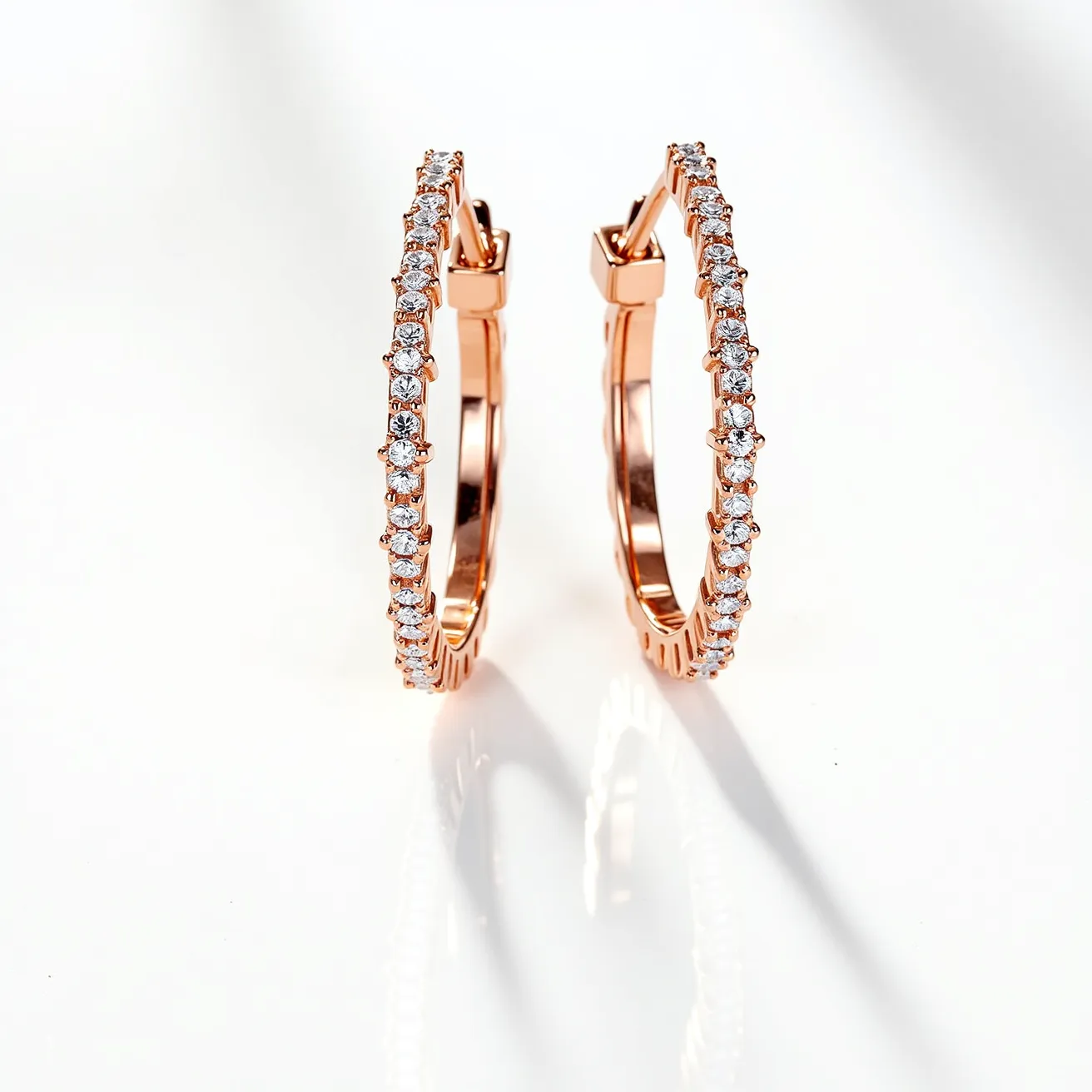 These diamond earrings feature a series of small, round-cut diamonds intricately set along the outer edge of elegant hoop designs. The hoops themselves are crafted from a lustrous rose gold, complementing the brilliance of the diamonds with their warm hue. Each diamond is securely held in place with a prong setting, allowing for maximum light reflection and sparkle. The earrings are equipped with a hinged clasp, ensuring a secure fit when worn. The combination of the rose gold and sparkling diamonds creates a classic yet modern accessory suitable for various occasions.