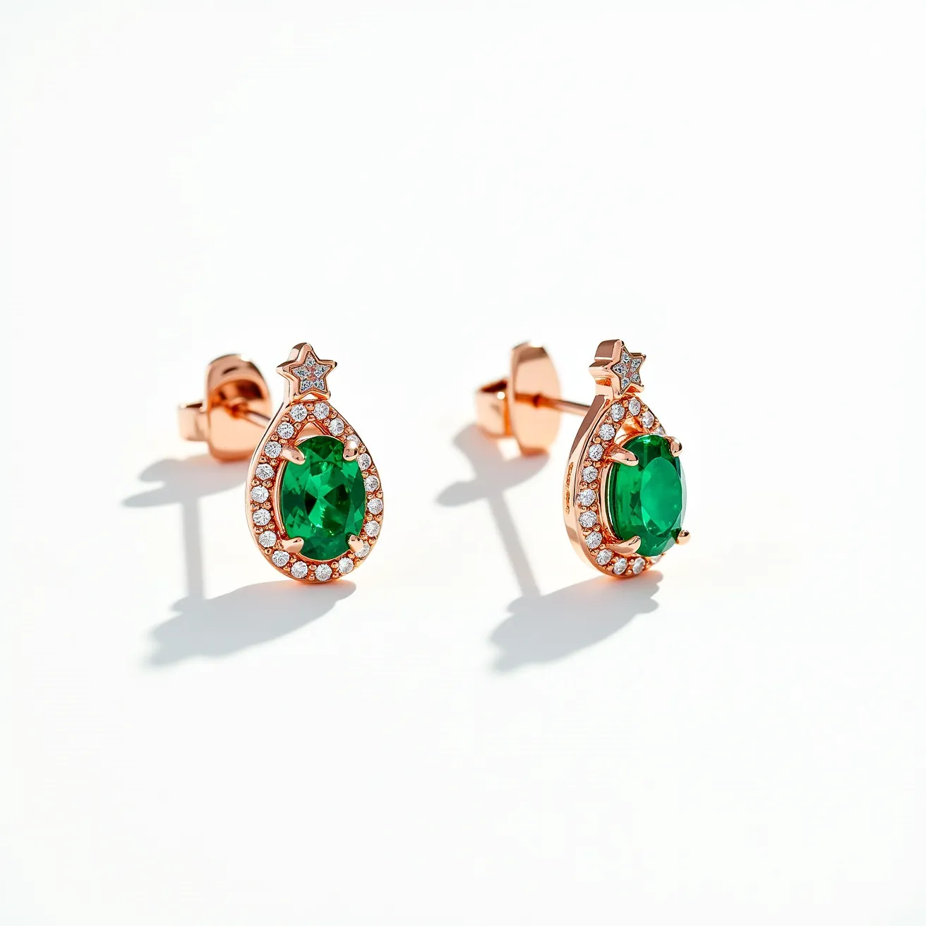 These diamond earrings feature an elegant teardrop design crafted in a warm rose gold metal, accentuated with a striking central emerald-green stone cut in an oval shape. The prominent gemstone is held securely in a prong setting, allowing light to highlight its vibrant color. Surrounding the central gem is a delicate halo of small, round-cut diamonds, adding a brilliant sparkle to the earrings. At the top of the teardrop, a star-shaped element is adorned with a single diamond, providing an additional touch of sparkle. These earrings are finished with a classic butterfly clasp, ensuring secure and comfortable wear.