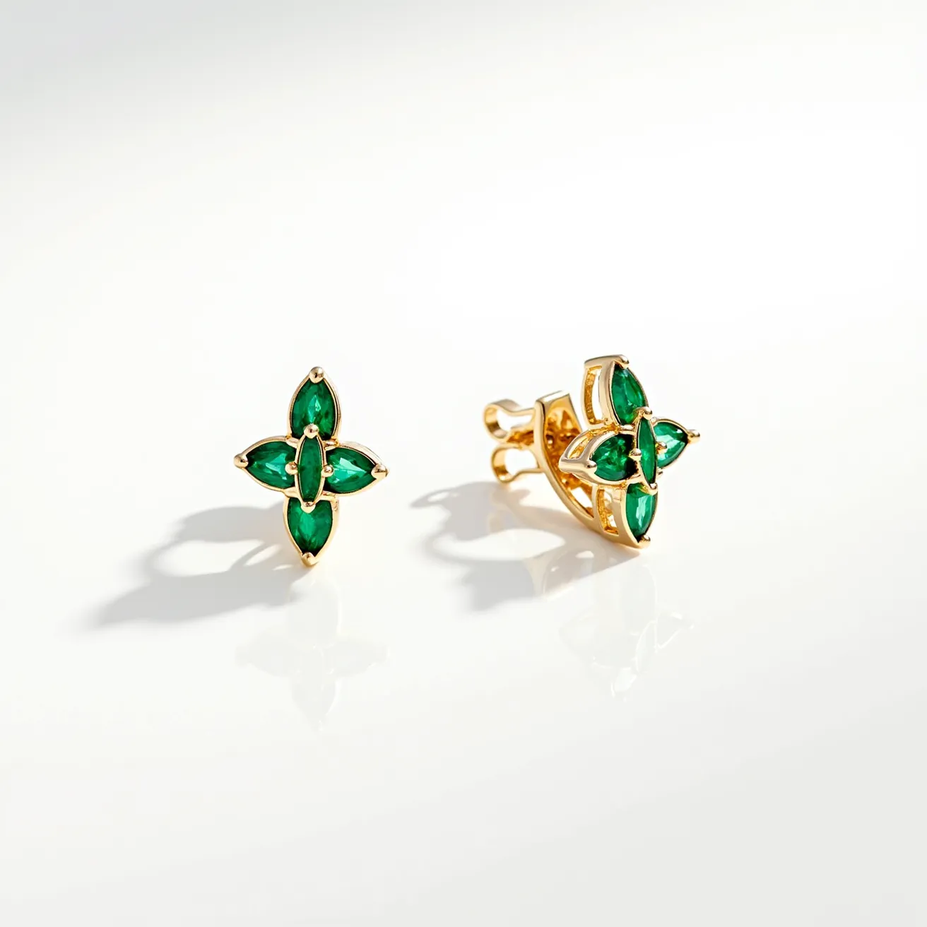 These emerald earrings feature a stunning design comprising four marquise-cut emerald gemstones delicately arranged in a floral motif. The gems are securely nestled in a polished gold setting, enhancing their vibrant green hue and brilliance. Each earring is equipped with a classic post and butterfly clutch back, ensuring a secure and comfortable fit. The combination of rich emeralds and gleaming gold gives these earrings a timeless elegance, suitable for both formal and casual occasions.