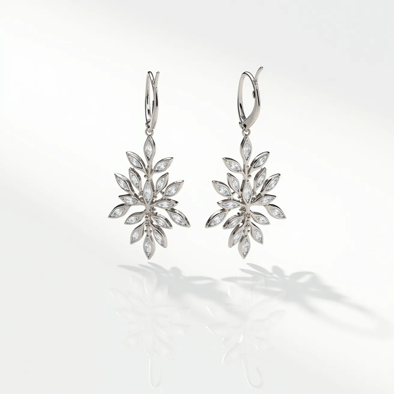 These floral earrings design features intricate patterns reminiscent of blossoming flowers, composed of fine materials such as silver or white gold. The earrings are adorned with marquise-cut stones, likely diamonds or cubic zirconia, each set securely in a bezel setting, which helps emphasize the elongated shape of the stones and enhances their reflective qualities. The design is symmetrical and elegant, contributing to its sophisticated aesthetic. These earrings are equipped with lever-back clasps, ensuring a secure and comfortable fit when worn.