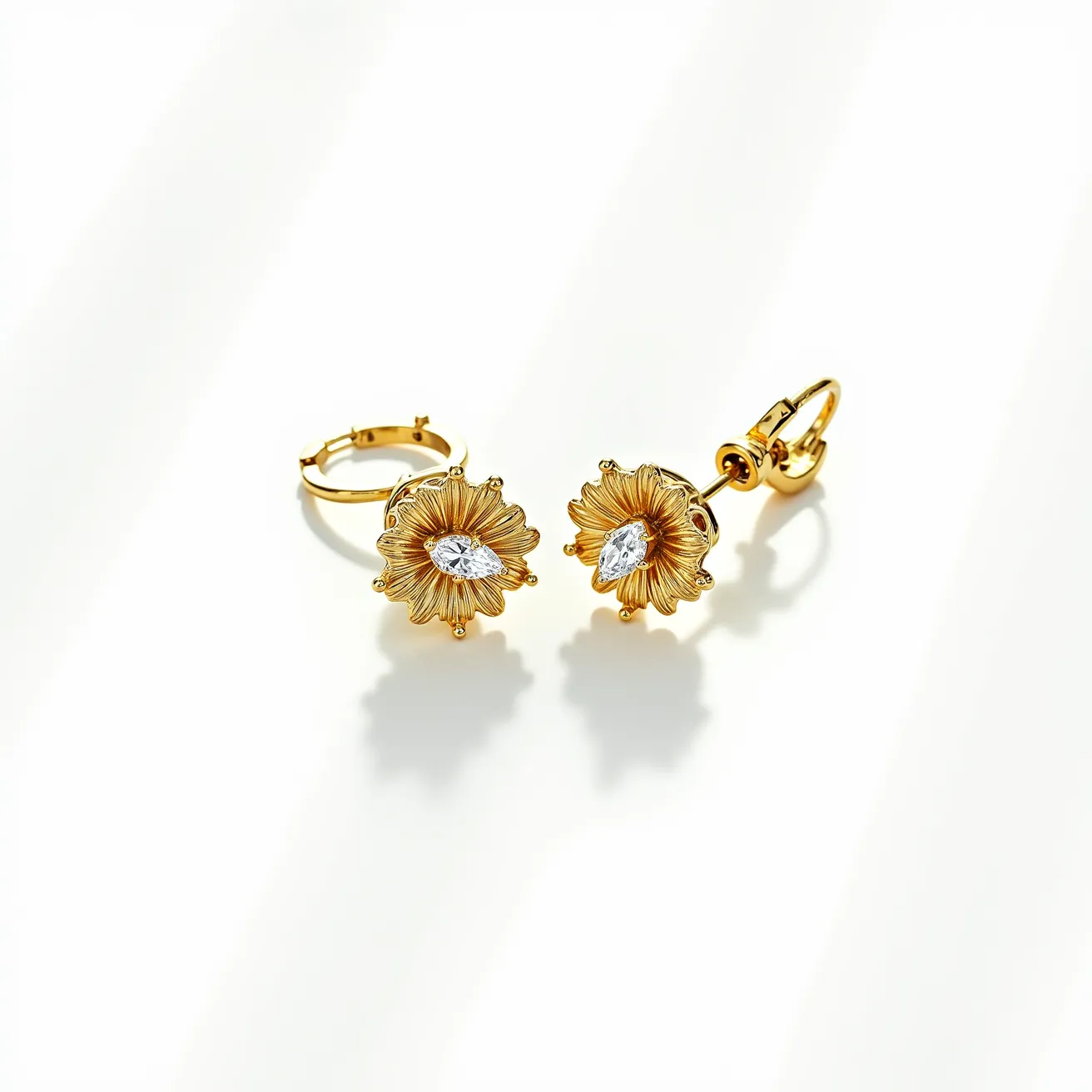 These floral earrings feature a charming design with a golden flower motif. At the center of each earring is a marquise-cut stone, likely a diamond or a similarly clear gemstone, securely set to add brilliance. The petal-like structures are crafted to emulate delicate floral aesthetics, with fine detailing that suggests quality workmanship. The earrings are completed with a lever-back clasp, providing a secure and comfortable fit for the wearer. The combination of the golden hue and the sparkling central stones creates an elegant and timeless appeal.