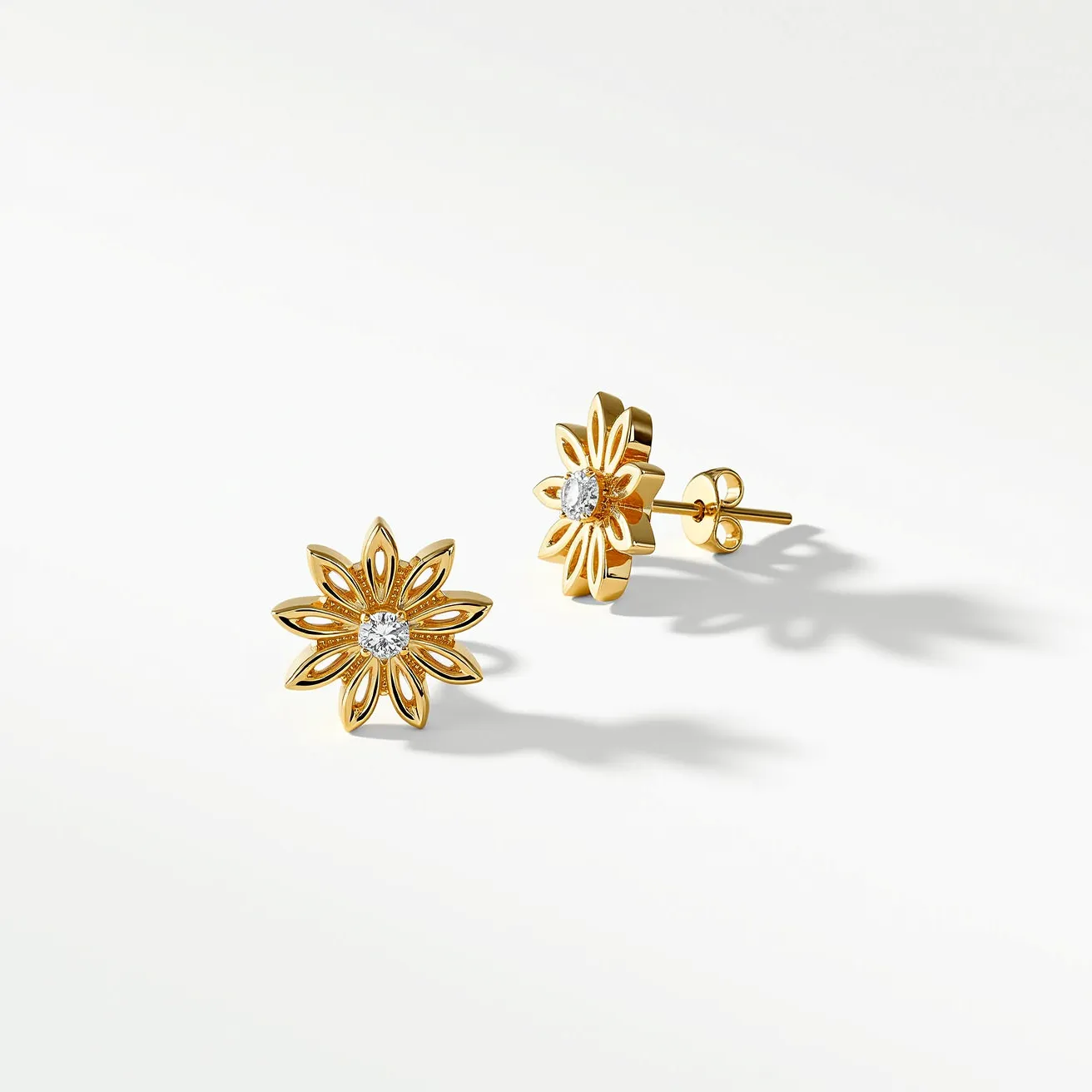 These floral stud earrings feature a delicate and intricate design with gold as the primary material, forming a charming flower shape. At the center of each earring is a round, brilliant-cut gem set in a secure bezel setting, likely a diamond, which adds a touch of elegance and sparkle. The earrings are equipped with a secure post and push-back clasp, ensuring ease of wear while maintaining flexibility and comfort. The combination of gold and gemstones creates a sophisticated yet timeless appeal, making these earrings a versatile accessory.