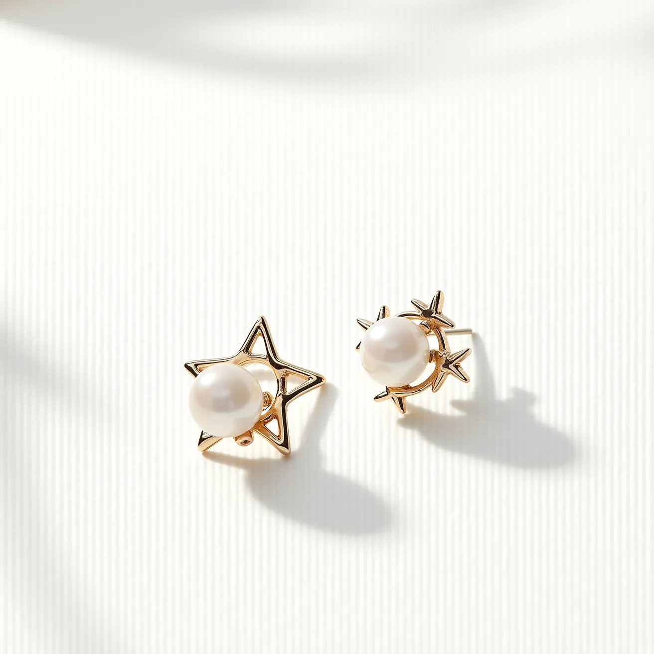 These gold cartilage earrings feature a unique design with a celestial theme, showcasing a star and a small crescent moon each adorned with a lustrous pearl. The pearls serve as the central gems, adding a classic touch with their smooth, round cut and reflective surface. The gold framework forms distinctive shapes, with the star having openwork detailing and the crescent moon embellished with tiny gold stars. These earrings are designed for cartilage, suggesting a stud post with a secure backing to keep them in place, providing both style and comfort.