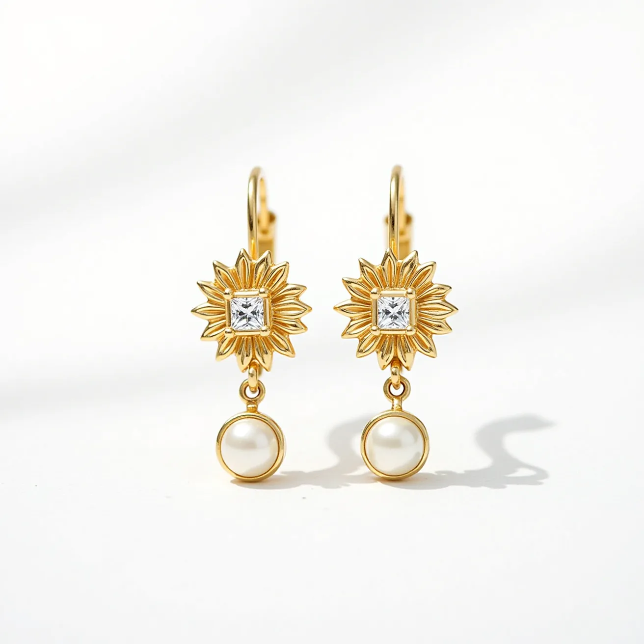 These gold cartilage earrings feature a unique design with a delicate floral pattern as the central motif. At the heart of each floral design is a square-cut clear gemstone, possibly a diamond or cubic zirconia, held firmly in place. Beneath this intricate floral setting dangles a smooth, round pearl, adding elegance to the earrings. The earrings utilize a French hook clasp, ensuring secure attachment while maintaining a classic and stylish appearance. The combination of gold, clear gemstones, and pearls offers a harmonious blend of refinement and sophistication.