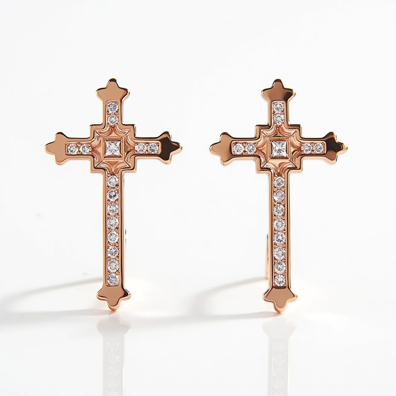 These gold cross earrings are crafted from gold and adorned with clear, round-cut stones embedded in a symmetrical pattern along the arms and base of the cross. At the center of each earring is a square-cut gemstone, set within a detailed frame that enhances its elegance. The stones appear to be securely held in place with a prong setting, providing both stability and a touch of sophistication. The earrings are likely designed with a post-back attachment, ensuring they are easy to wear and secure when worn. The combination of gold with the sparkling stones creates a harmonious balance of luxury and simplicity.