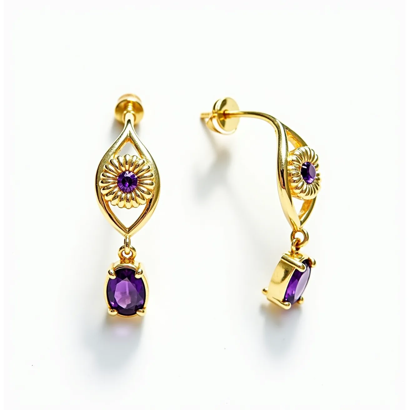 These gold earrings feature an elegant design that incorporates a smooth gold metal structure with intricate detailing. Each earring includes a central floral motif, adorned with a small, round-cut purple gemstone set neatly at the heart of the flower, enhancing the overall aesthetic. Dangling below, a larger oval-cut purple gemstone is securely held in place by a classic four-prong setting, adding movement and a touch of sophistication. The earrings are designed with a stud post and butterfly clasp, ensuring a secure and comfortable fit when worn.