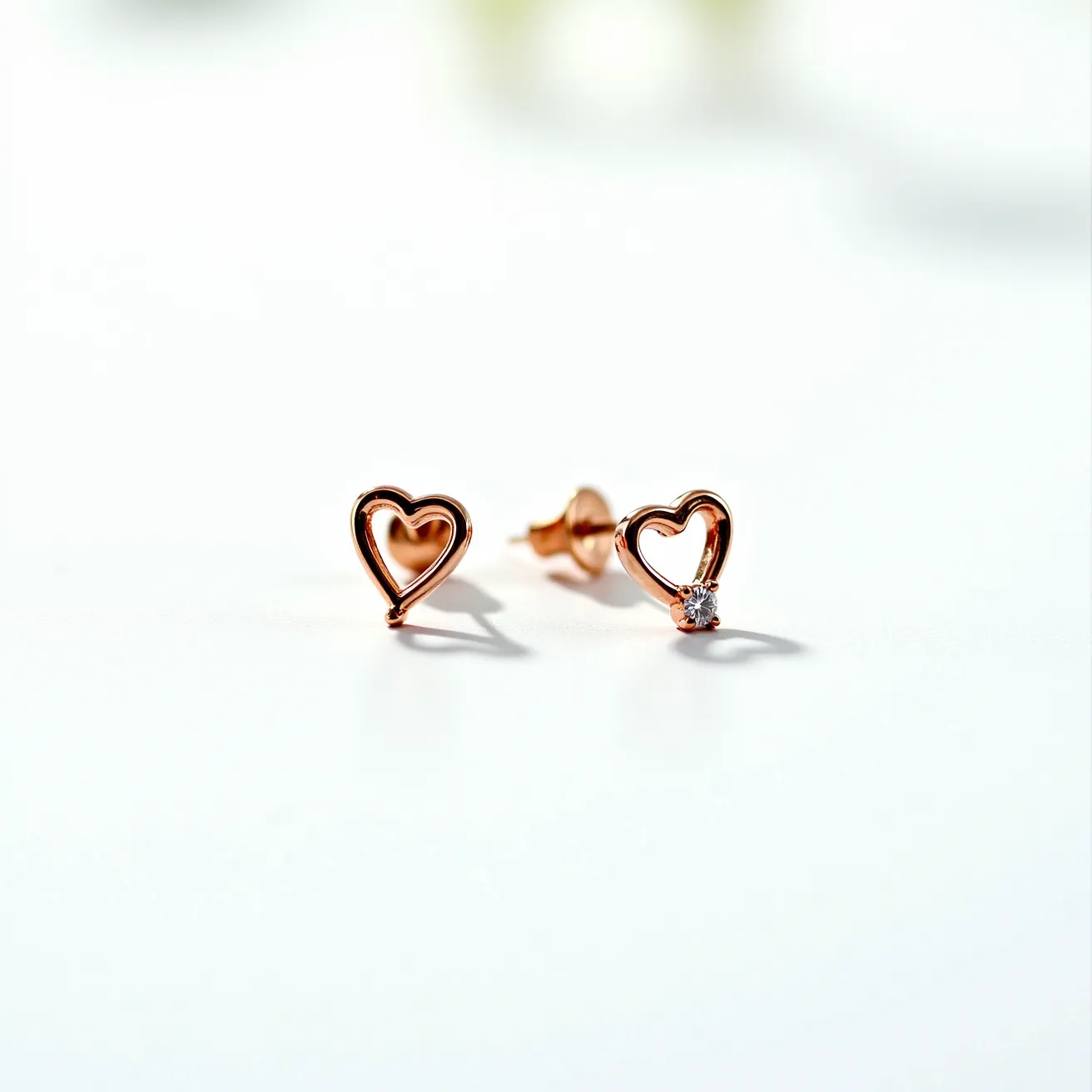 These gold heart earrings feature a delicate open-heart design crafted from a warm gold material that gives them a classic and elegant look. One of the earrings is adorned with a small round gemstone, likely a diamond, which is set into the lower curve of the heart, adding a touch of sparkle. The gemstone is set in a simple prong setting, ensuring it is securely held in place. These earrings are designed with a post and butterfly clutch back, providing a secure and comfortable fit for the wearer.