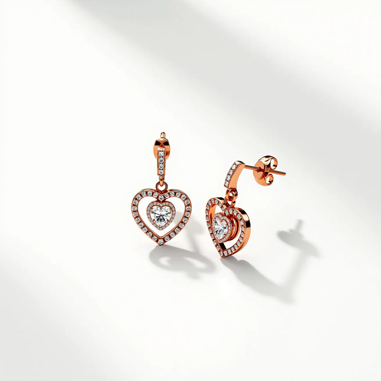 These gold heart earrings feature a charming design with a central heart-shaped gem, likely a clear, faceted diamond, encased in a delicate golden heart setting. Surrounding the central stone, the earrings display a border embellished with small, round-cut diamonds, adding a sparkling effect. The earrings are suspended from a series of additional small diamonds set in a line, connecting to a secure post-back clasp, ensuring both style and comfort. The overall look combines elegance and sophistication, making these earrings a striking accessory.