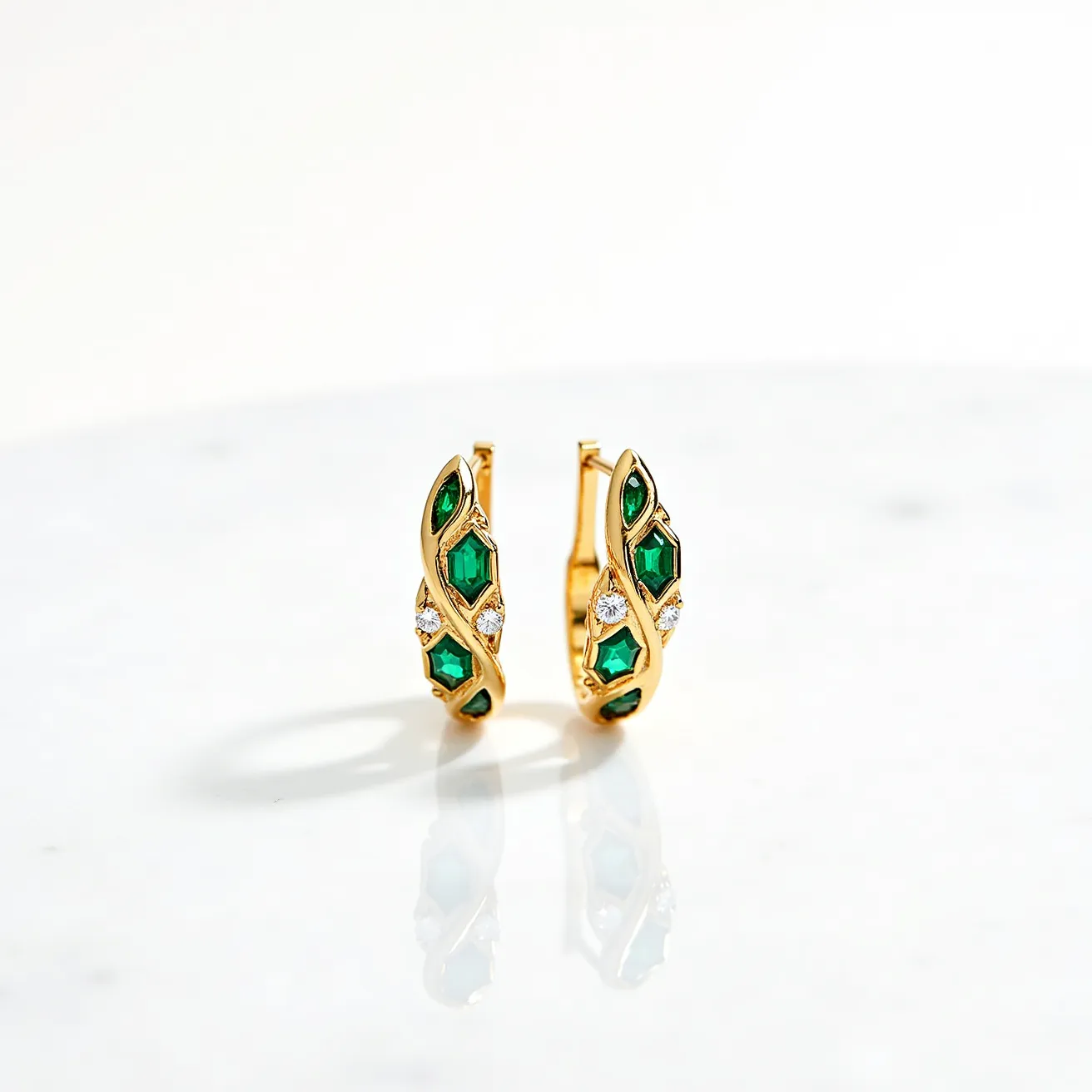 These gold hoop earrings feature a sleek, polished design, showcasing a radiant golden hue. Each earring is embellished with vibrant green gems, possibly emeralds, cut in a baguette shape, which are intricately set along the curve of the hoop. Accompanying the green stones are small, round, white gems, likely diamonds, adding a touch of sparkle. The stones are elegantly set in a symmetrical pattern that enhances the luxurious aesthetic. The earrings use a secure latch back closure, providing both elegance and practicality for everyday wear.