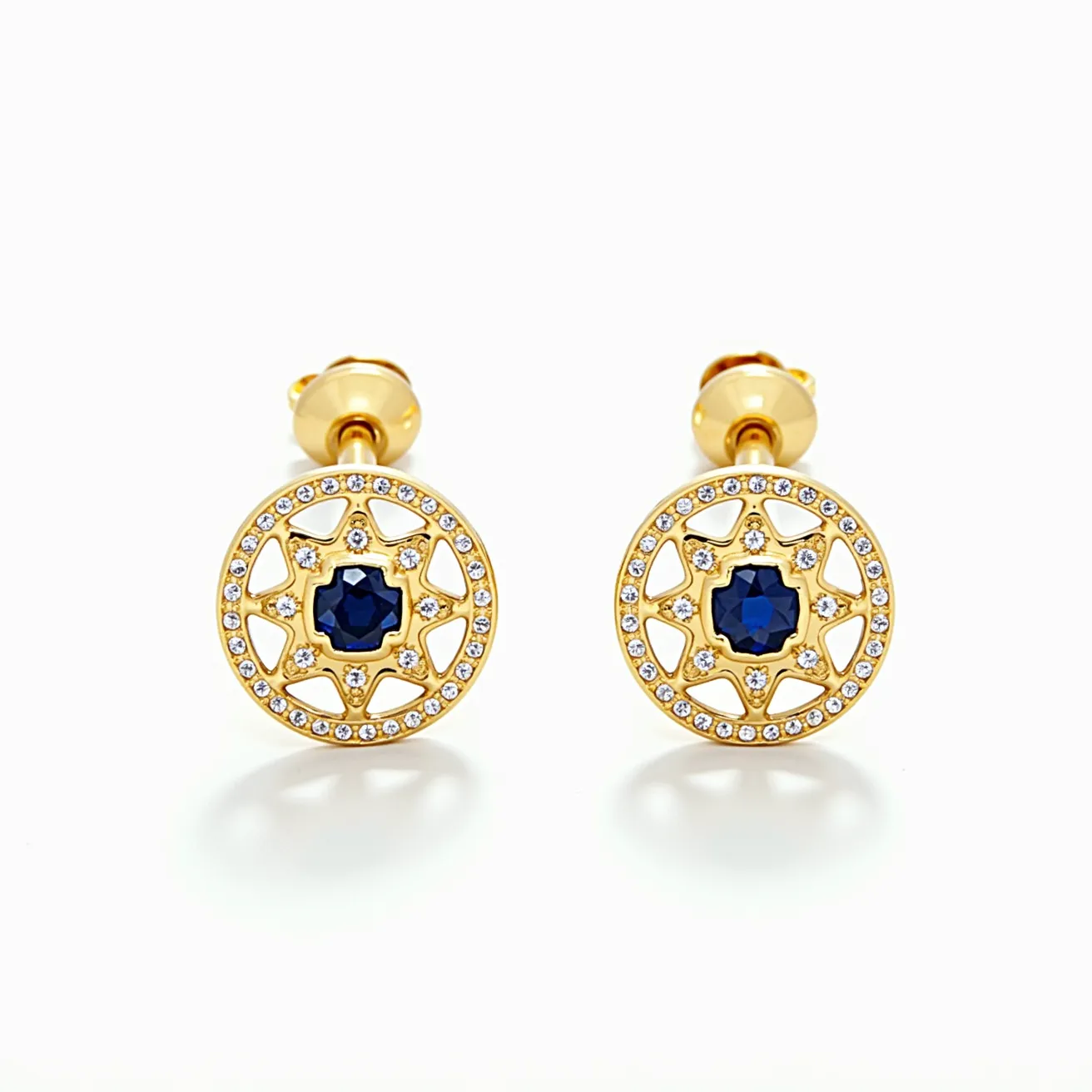 These gold stud earrings feature a luxurious design with a central deep blue, faceted gemstone that appears to be a sapphire, set in an openwork pattern of gold. The round gold discs are intricately detailed with small, brilliant-cut white diamonds that encircle the central stone, adding a touch of sparkle. The gemstone is set in a prong setting, securely held within the intricate latticework design. The earrings are fastened with a classic butterfly or friction back clasp, ensuring a secure fit while complementing the overall elegant appearance of the piece.