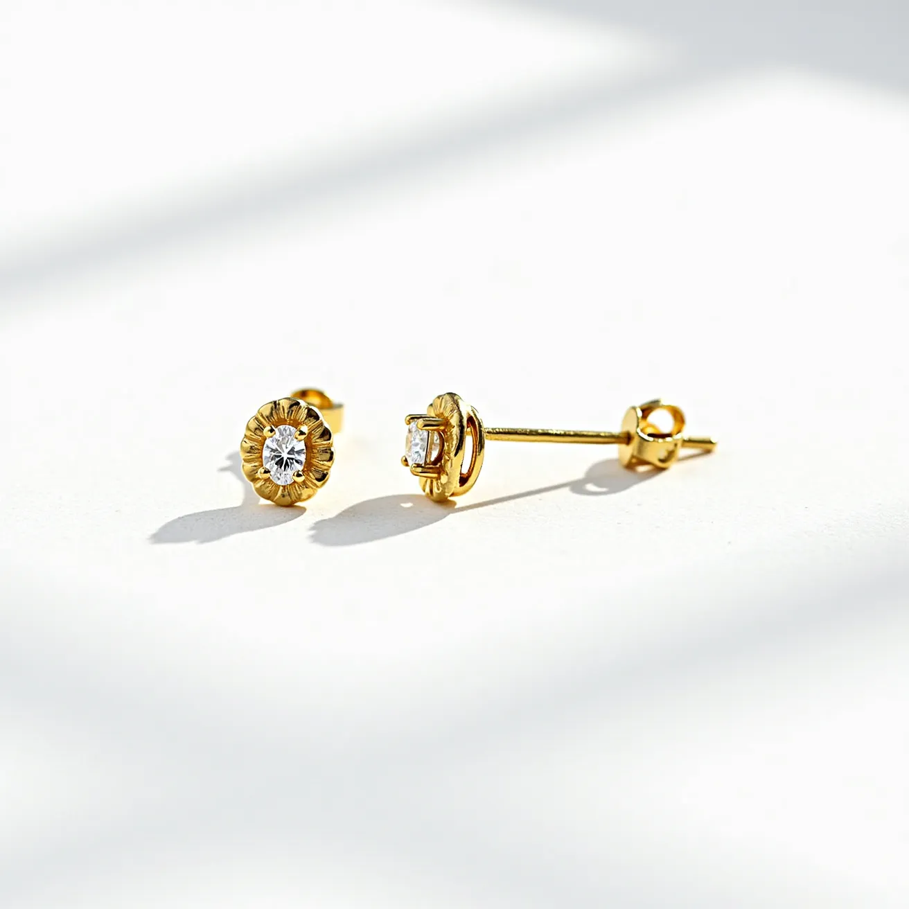 These gold stud earrings feature a classic design with a solitary, round-cut cubic zirconia set in a bezel. The shimmering gemstone is securely held in place, adding a refined sparkle to the overall presentation. The earrings are crafted with a polished gold finish, which complements the brilliance of the central stone. They are equipped with a butterfly clasp, ensuring a secure and comfortable fit for the wearer.